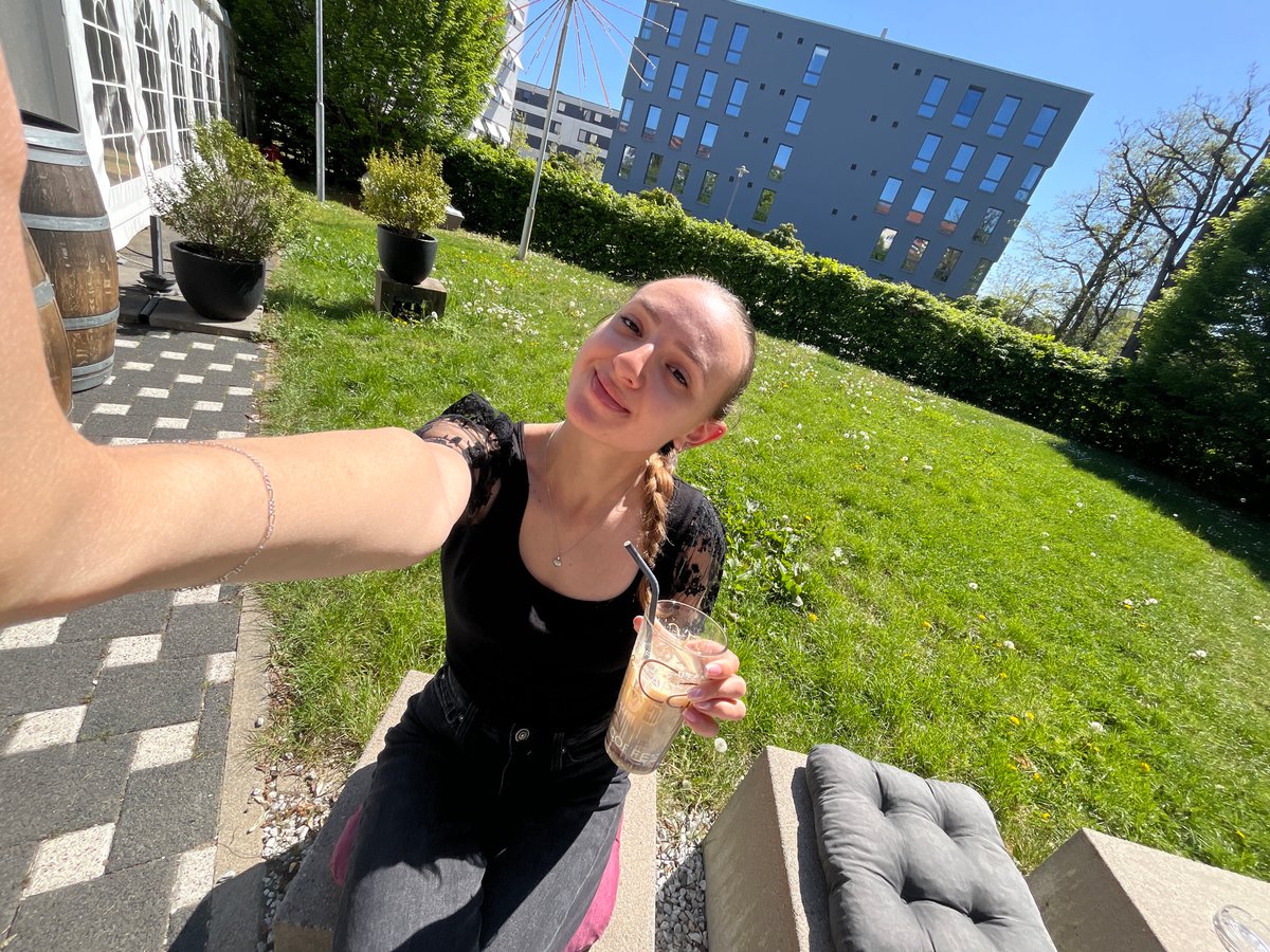 Woman enjoys iced coffee selfie moment in sunny Saarbrücken