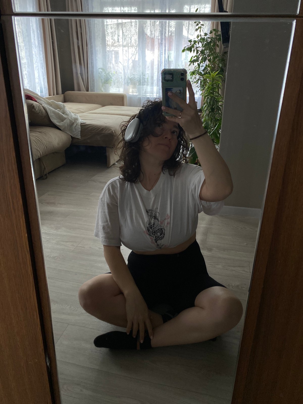 Woman Takes Mirror Selfie on Wooden Floor