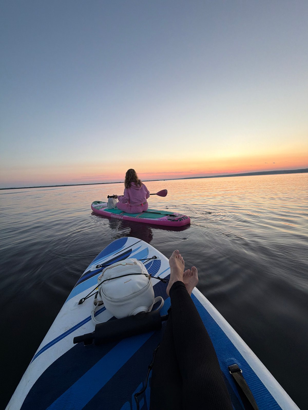 Sunset paddleboarding and boating on a calm Russian waterway