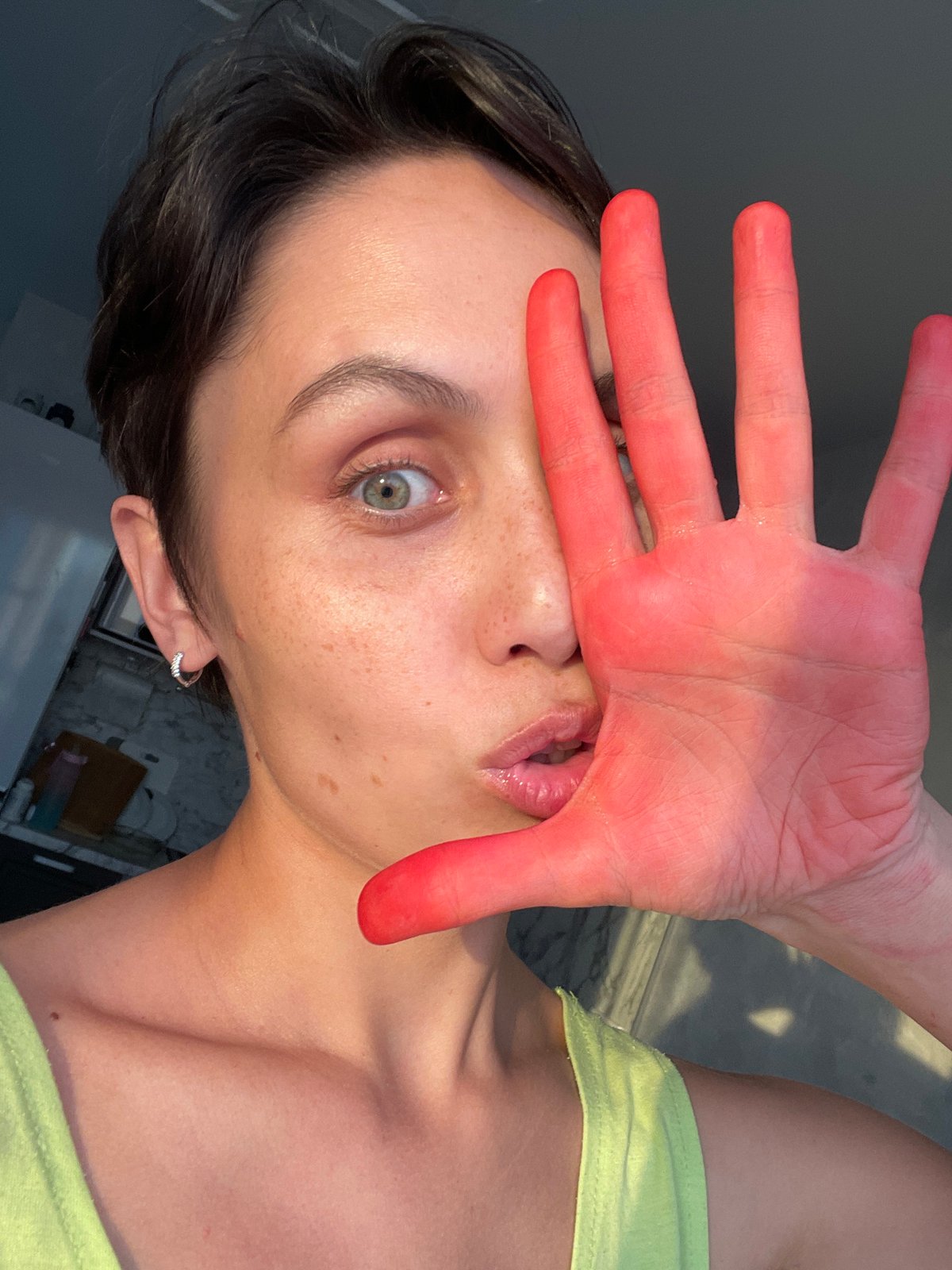Person photographed with red-tinted hand covering face in Izhevsk