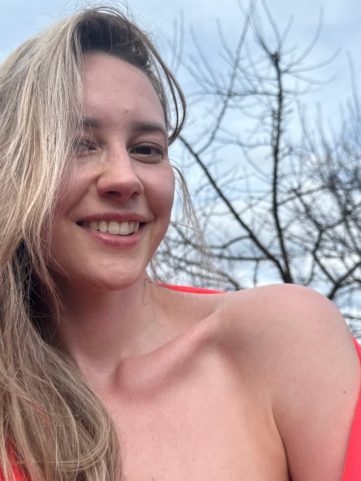 Woman poses for photos along riverbank in Chaikovsky, Russia