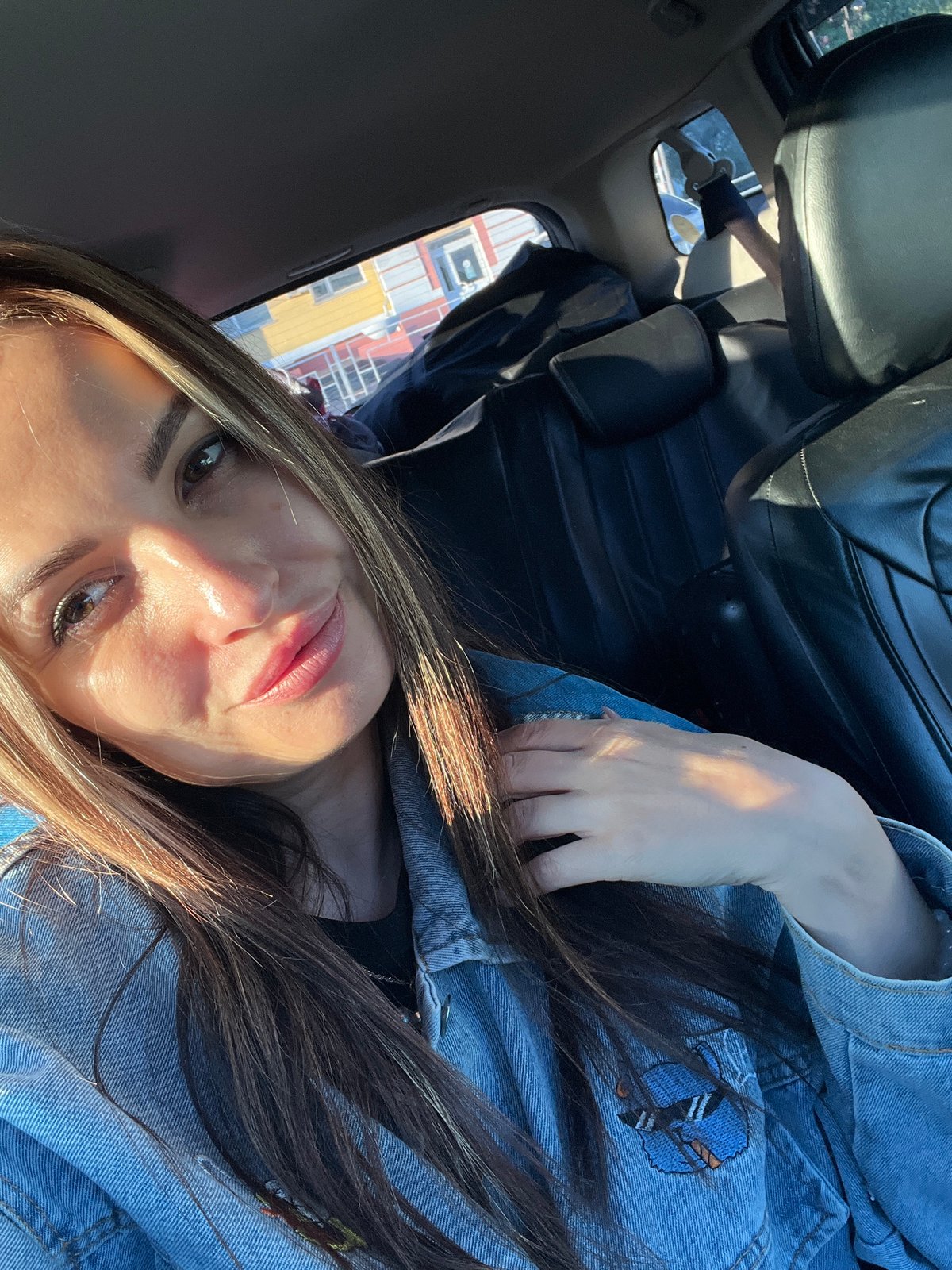 Woman in denim jacket documented during car journey