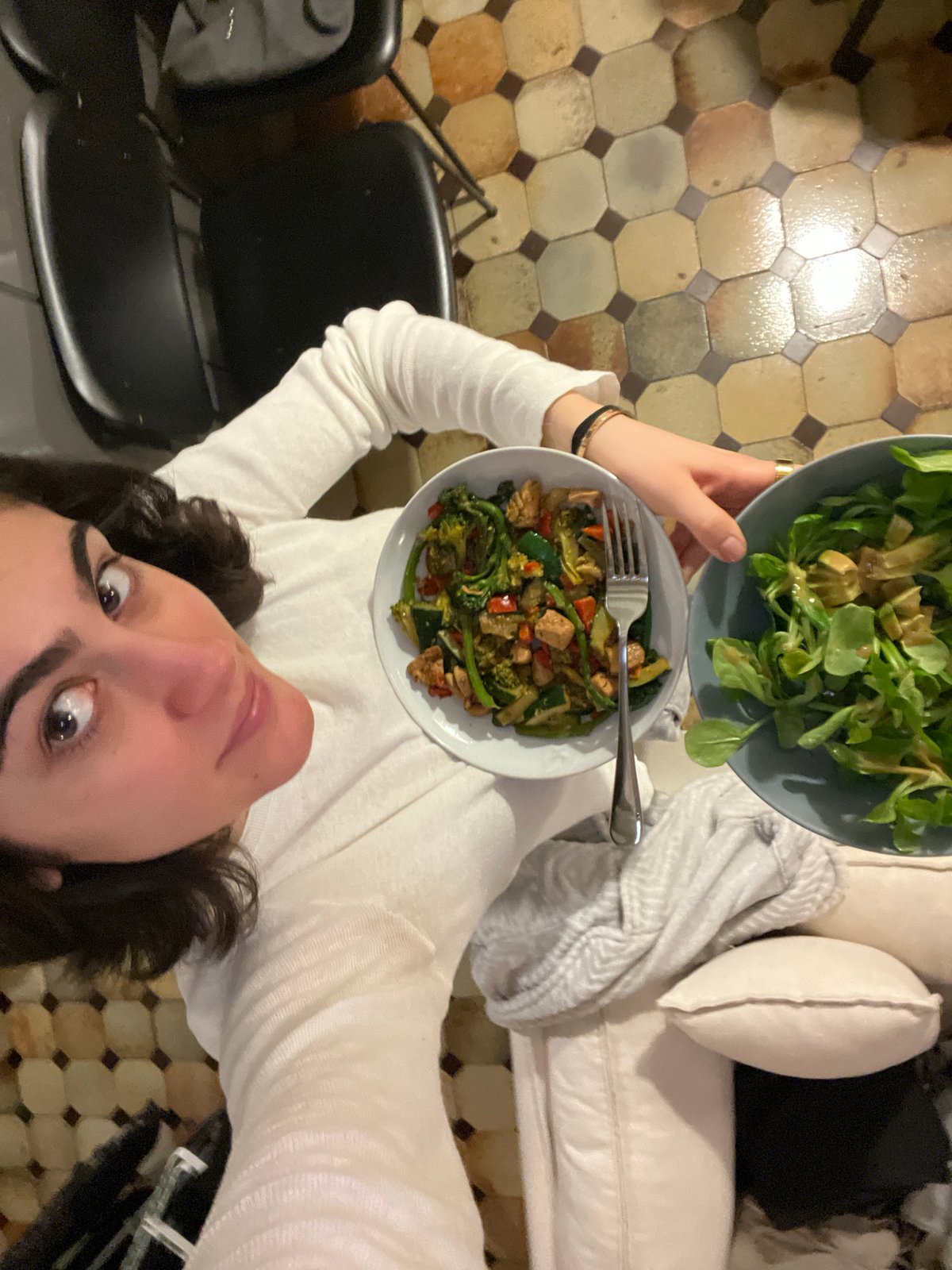 Woman holds two bowls of healthy food in Paris