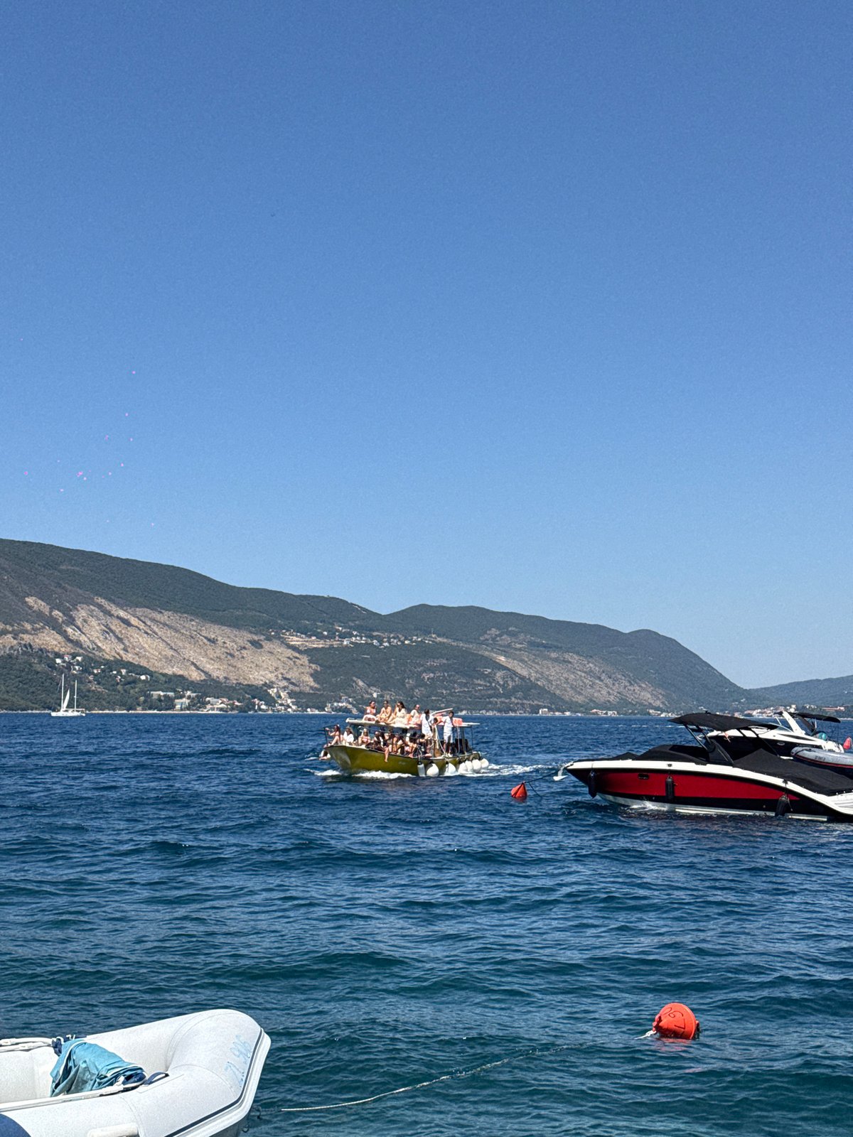 Sunny coastal stop with boats, bougainvillea, and waterfront views
