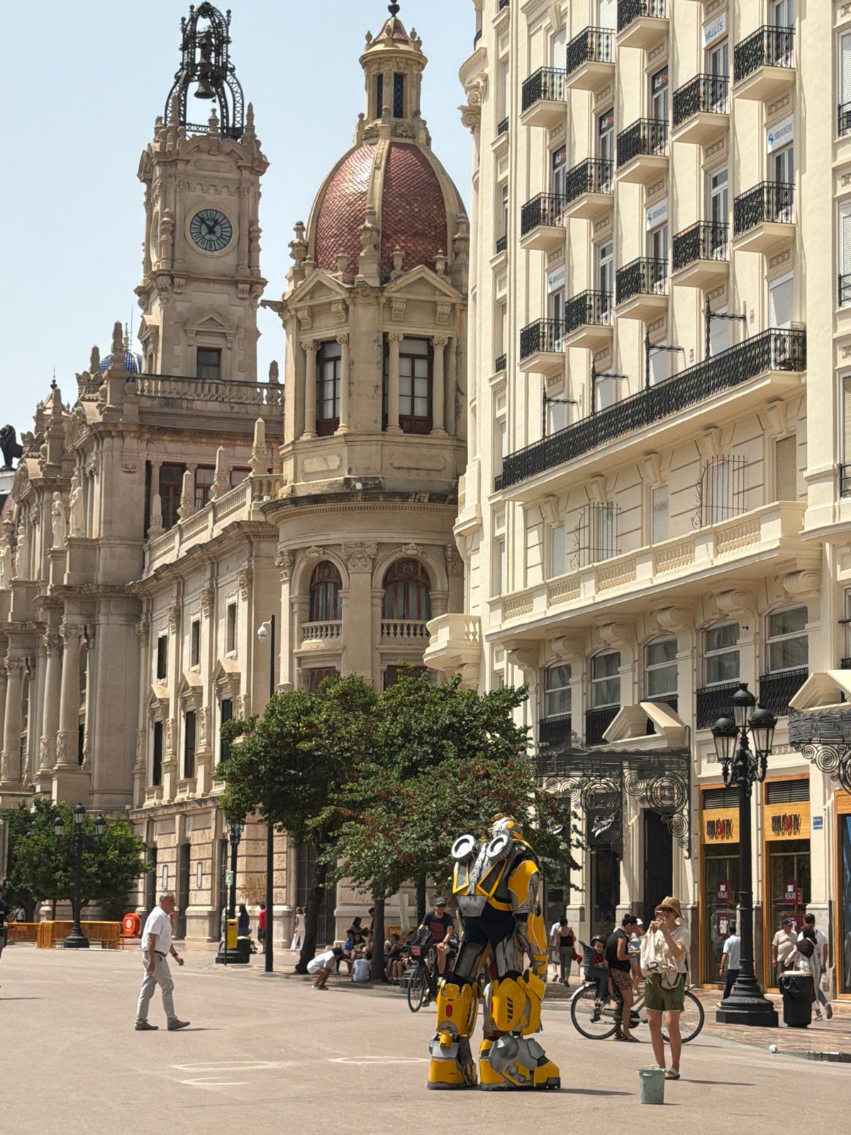 Bumblebee cosplayer, cherry blossom café, and jamón in a city square