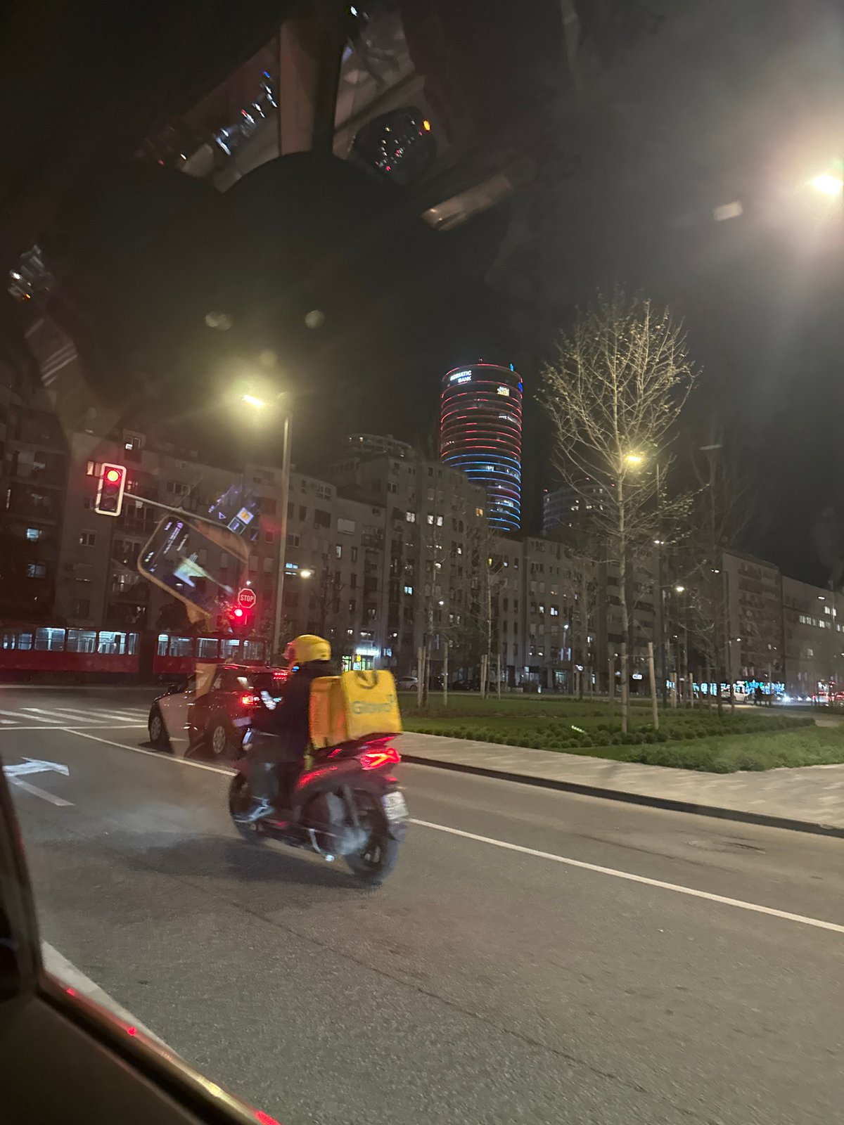 Delivery scooter stops at red light in Belgrade
