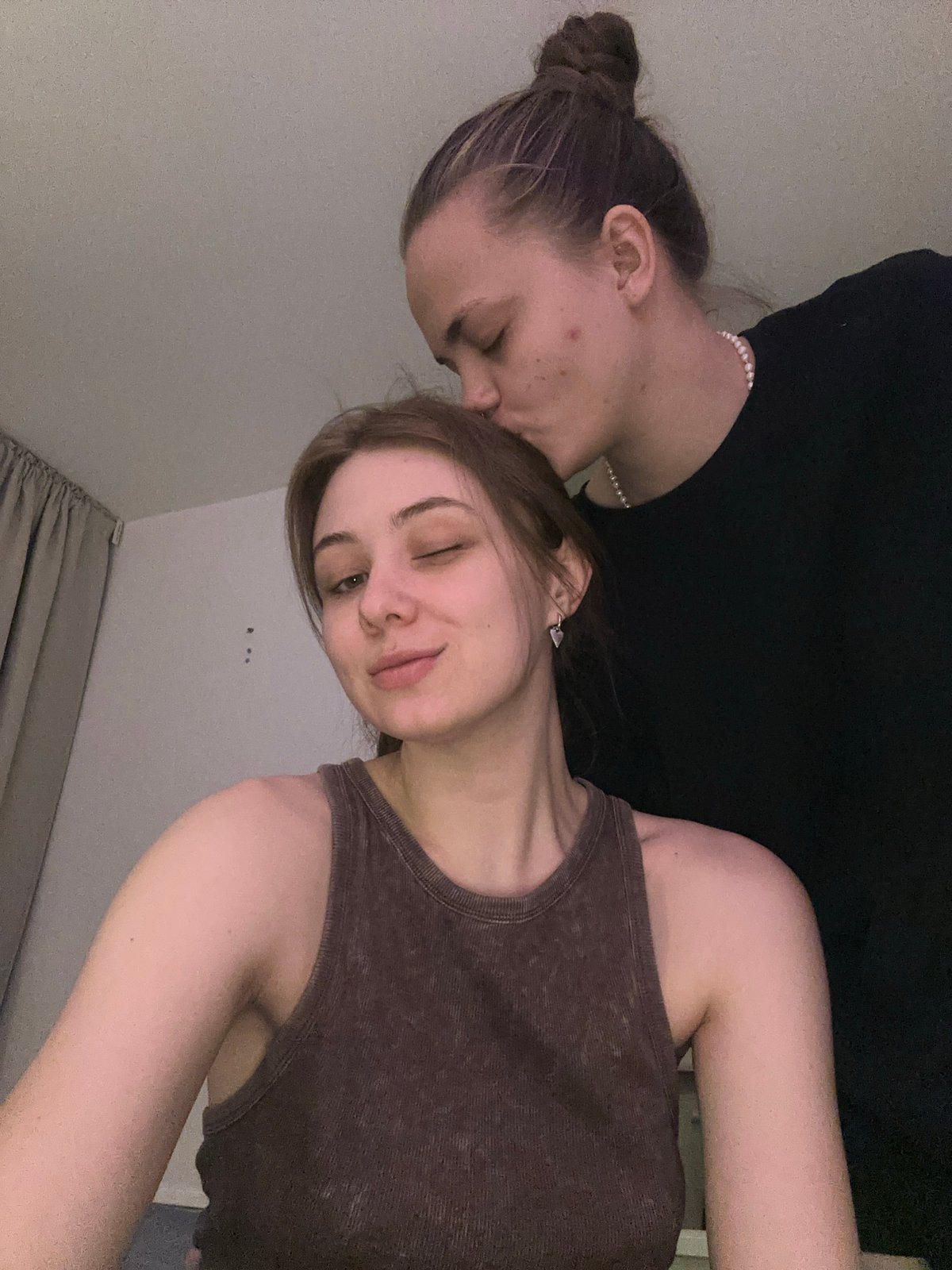 Two women pose intimately indoors in Moscow