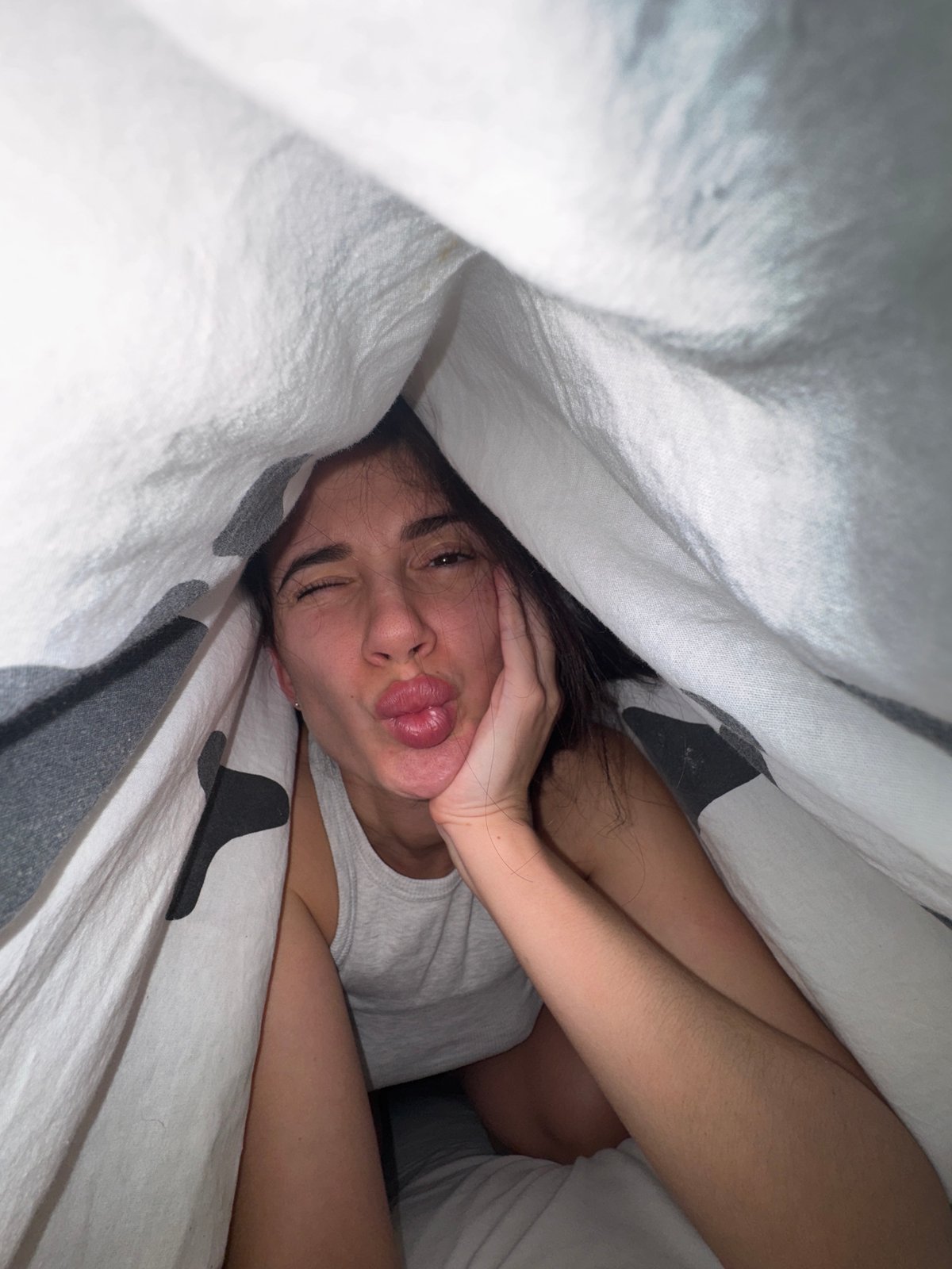Person makes pouting face while lying in bed in Chaikovsky