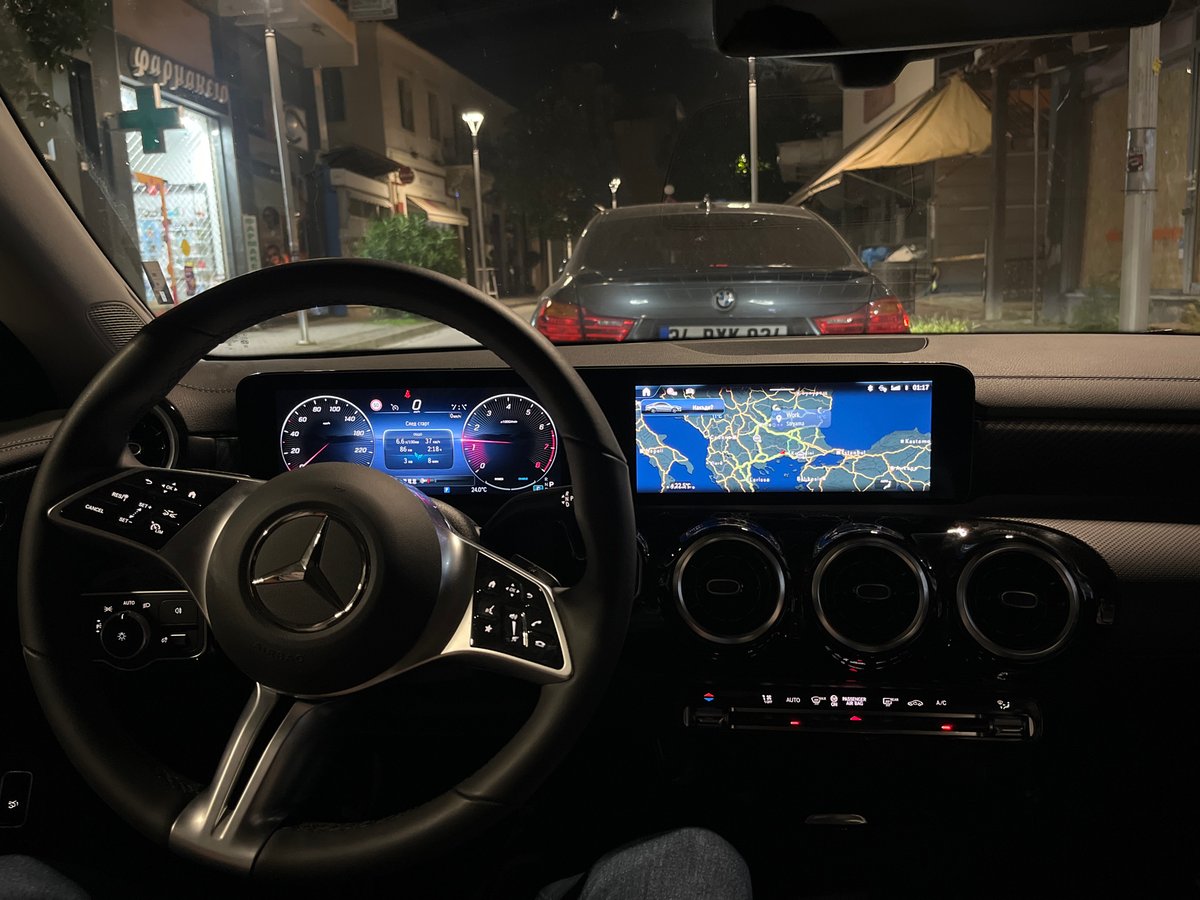 Mercedes dashboard displays navigation data during nighttime drive in Xanthi
