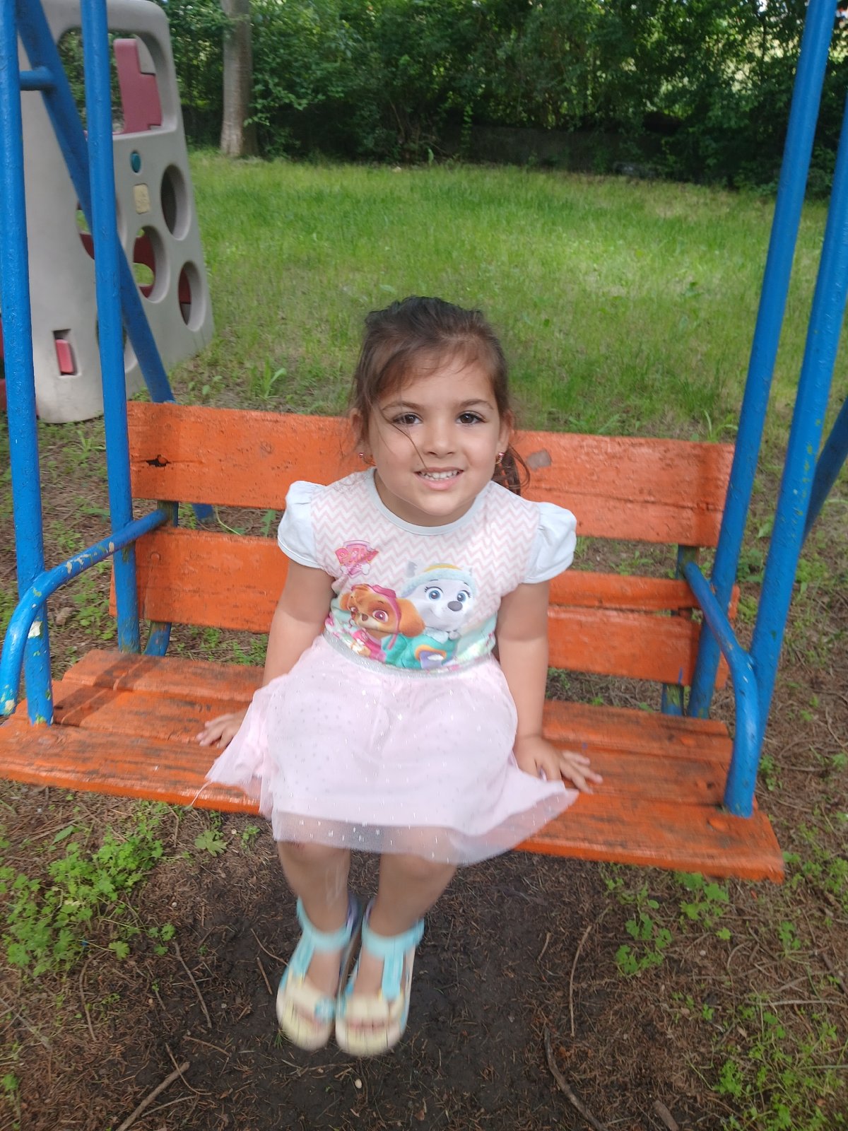 Children play on swings, merry-go-round in Dobrich playground