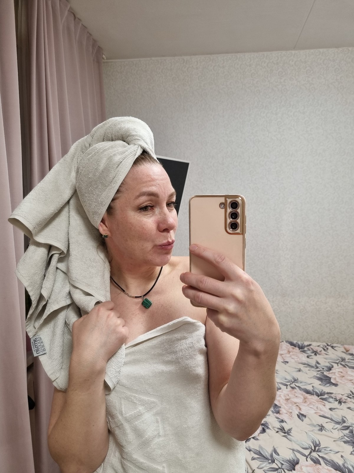 Woman takes post-bath selfies in bedroom in Chaikovsky