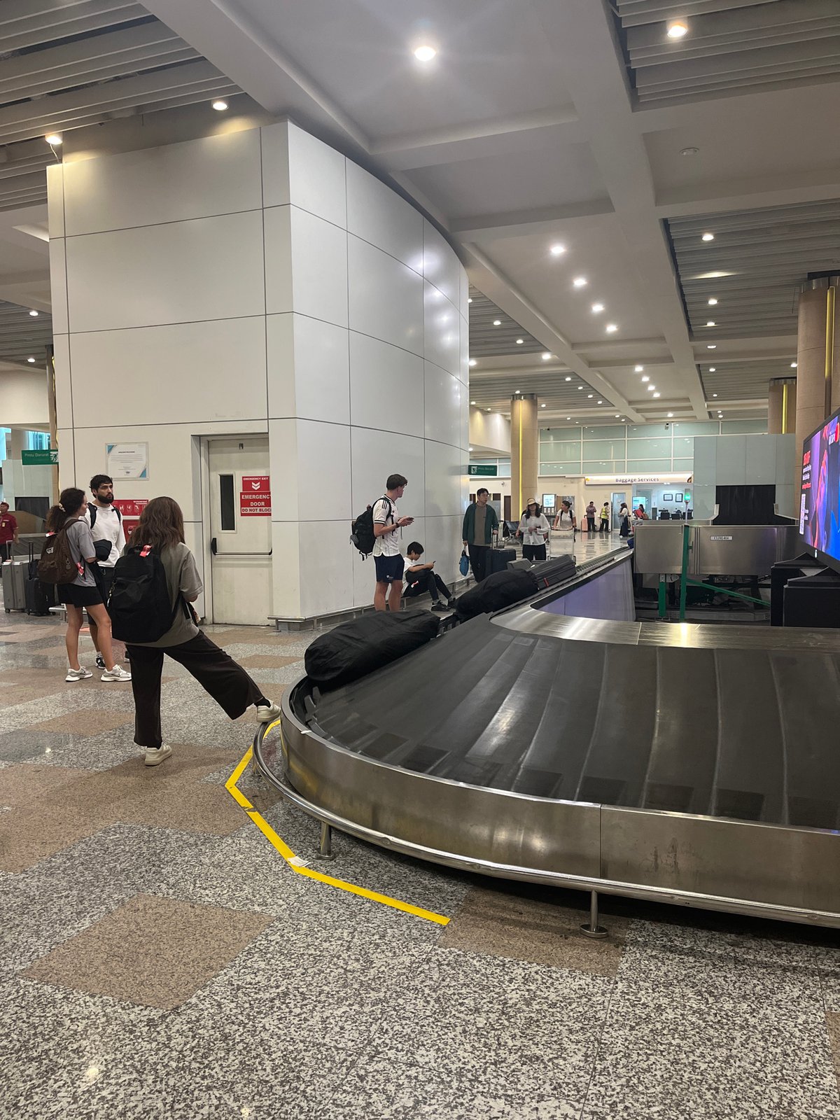 Morning baggage claim activity at Kuta airport terminal
