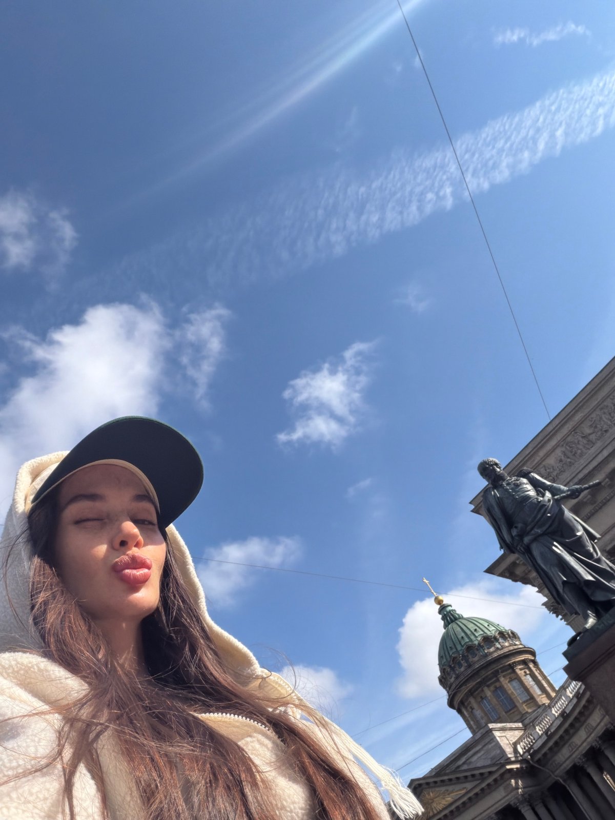 Tourist takes selfies at Kazan Cathedral on sunny Petersburg afternoon