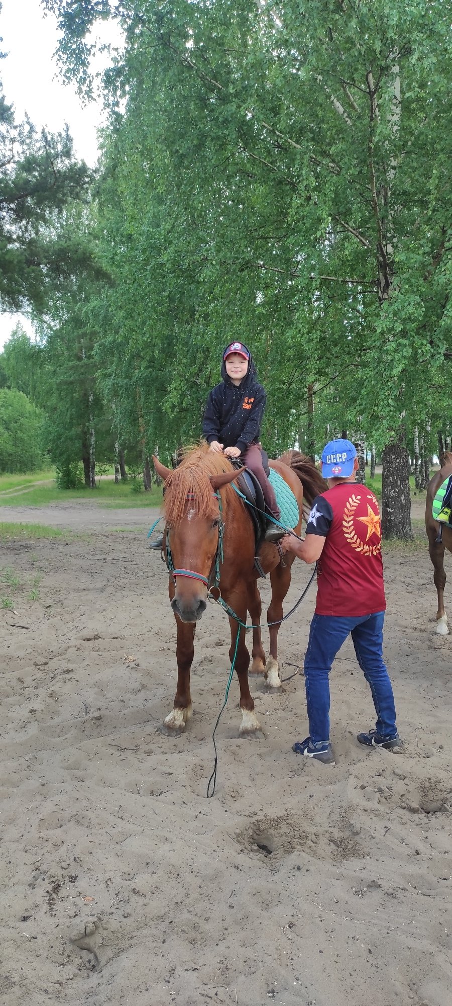 Horseback riding on a sandy riverside clearing in rural Russia