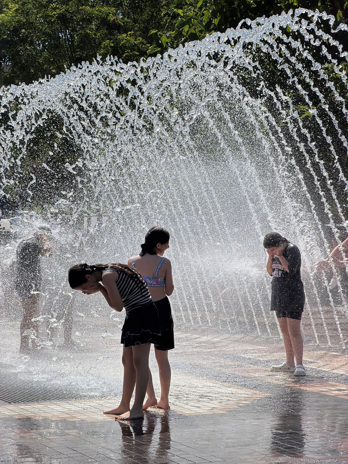 Kids cool off at a Yerevan splash pad on a summer morning