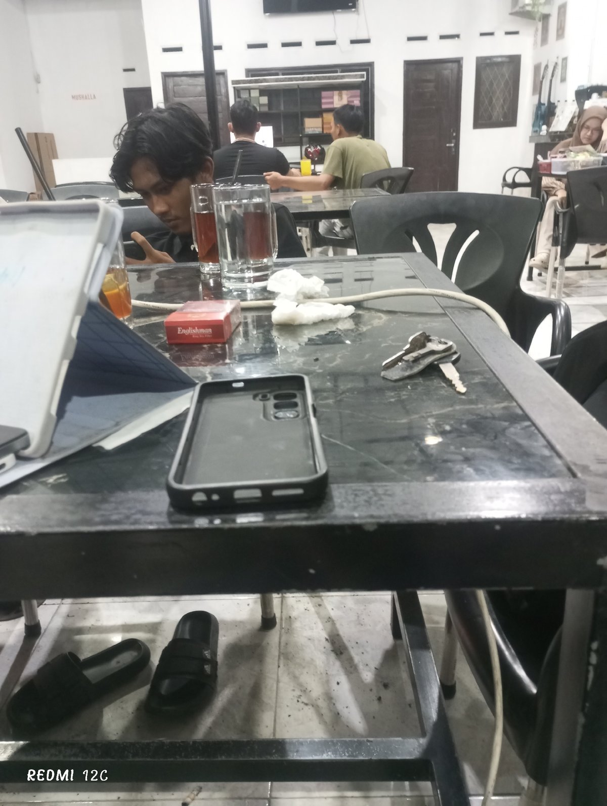 Young men use phones at Lhokseumawe cafe