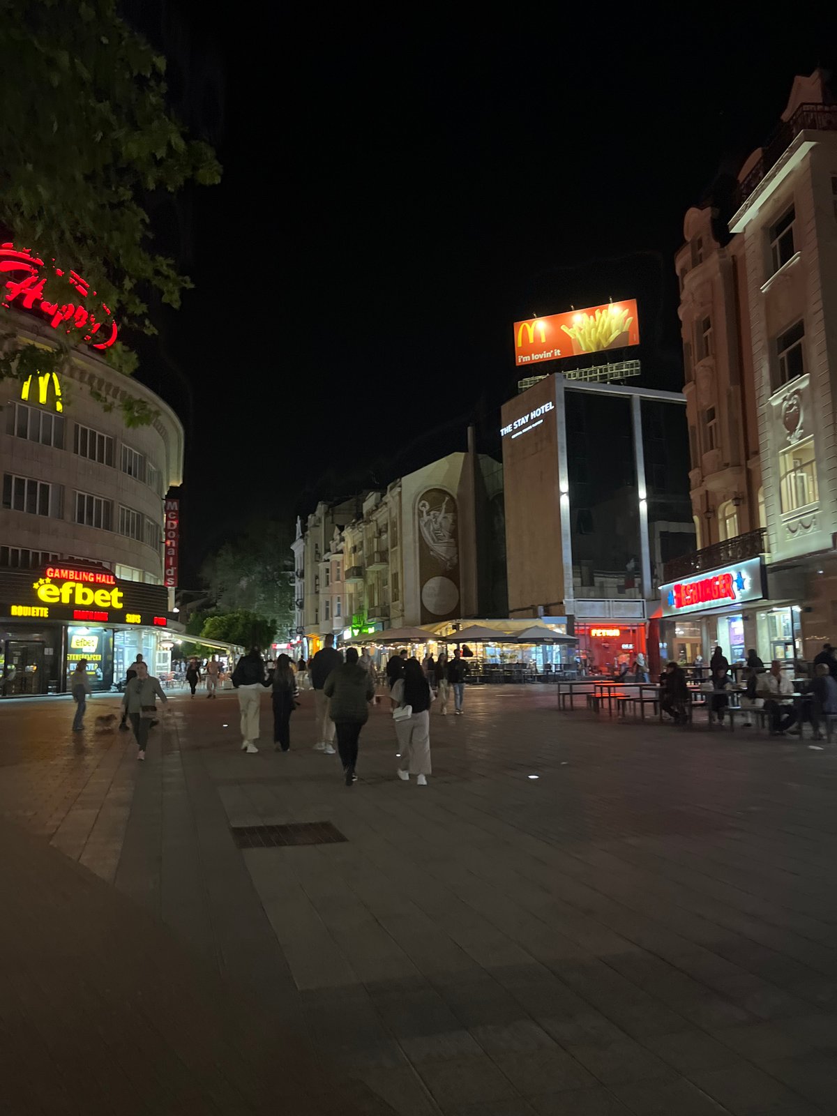 Evening pedestrians stroll central Plovdiv streets near commercial district