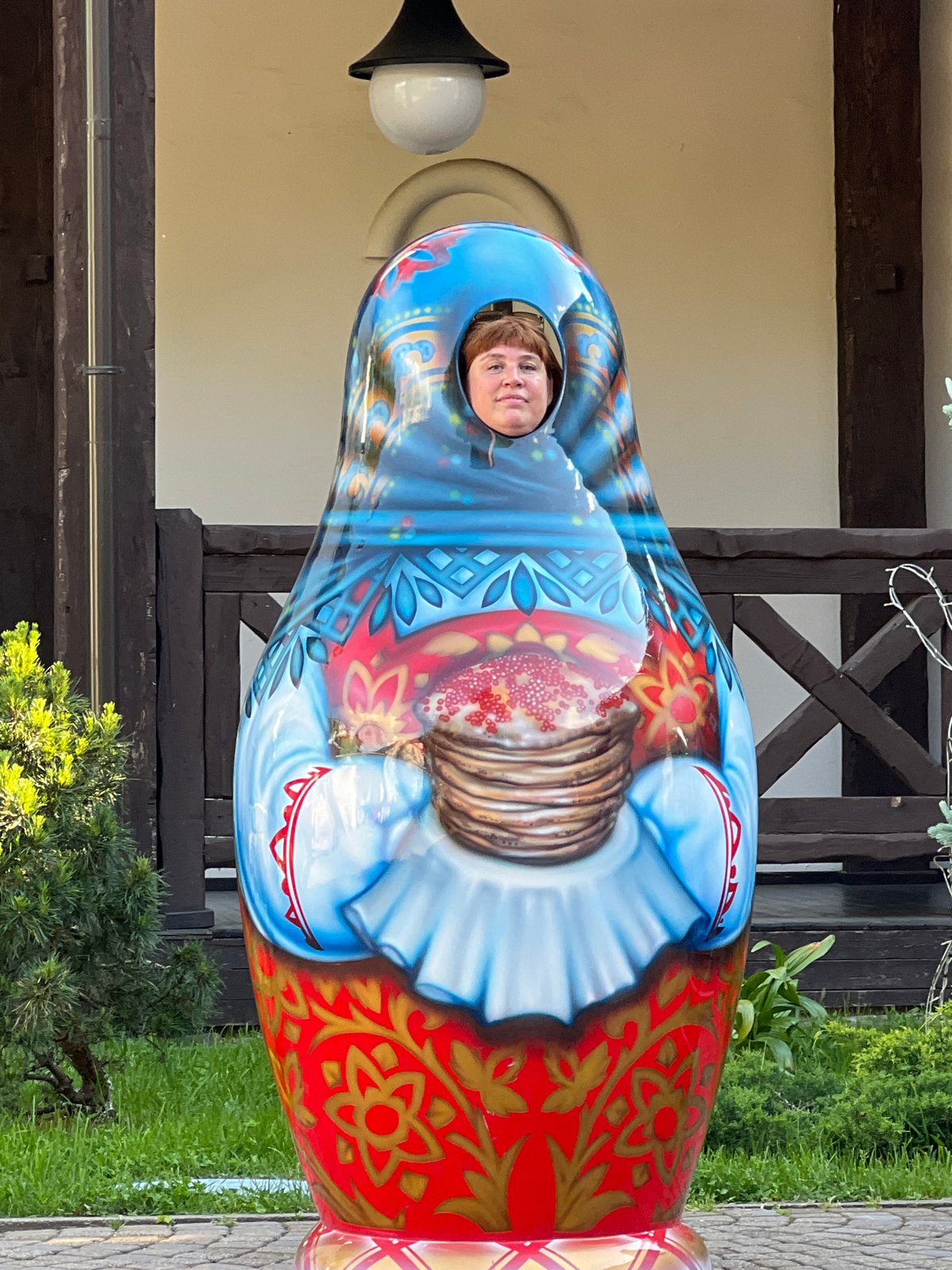 Tourist visits Russian cultural site, poses with matryoshka prop