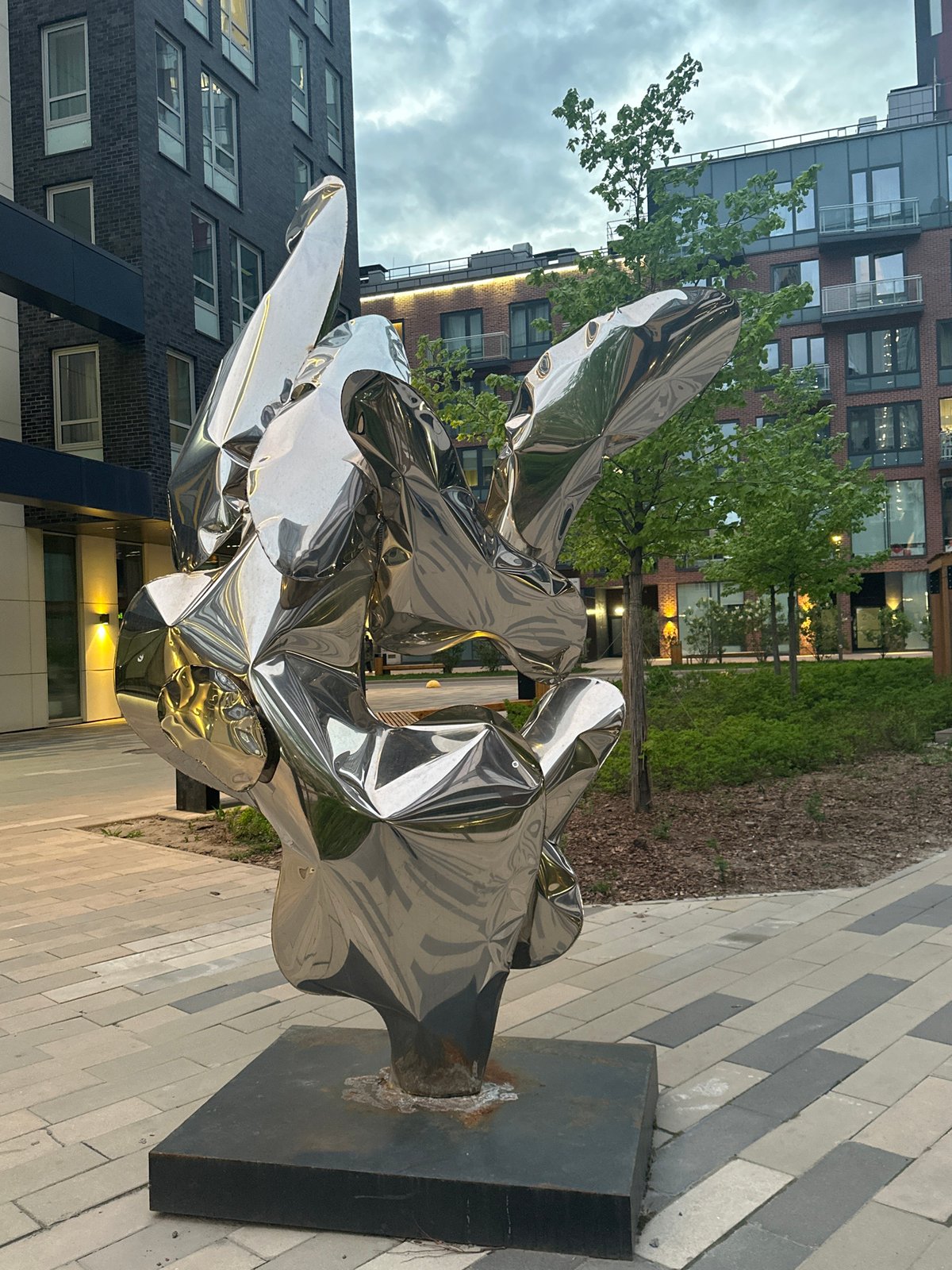 Reflective metallic sculpture spotted on urban brick walkway