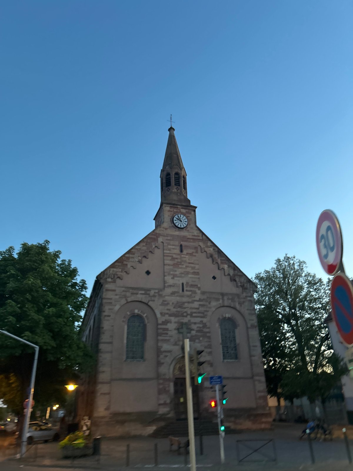 Stone church with clock steeple on a clear day in Strasbourg