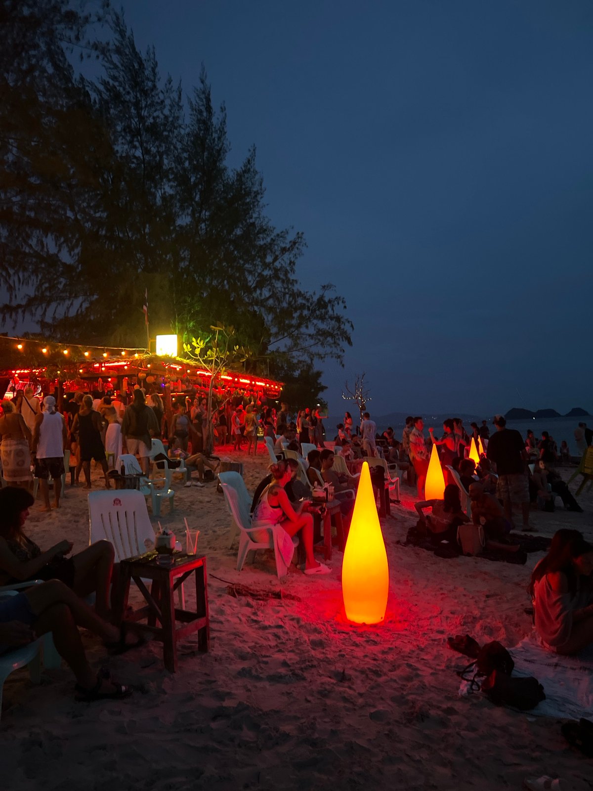Dusk beach party with fire performance and bar crowd, Ko Pha-ngan