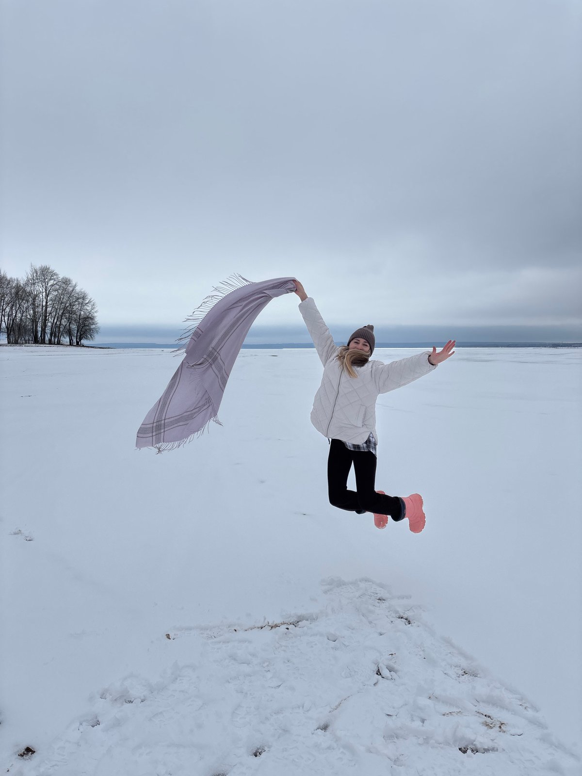 Person poses with scarf in snowy Chaikovsky landscape