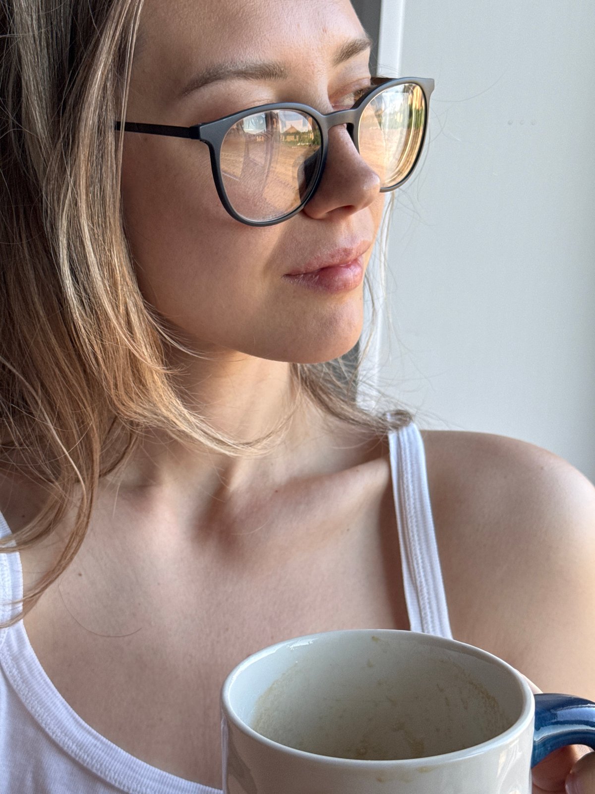 Woman with coffee mug photographed indoors in Chaikovsky