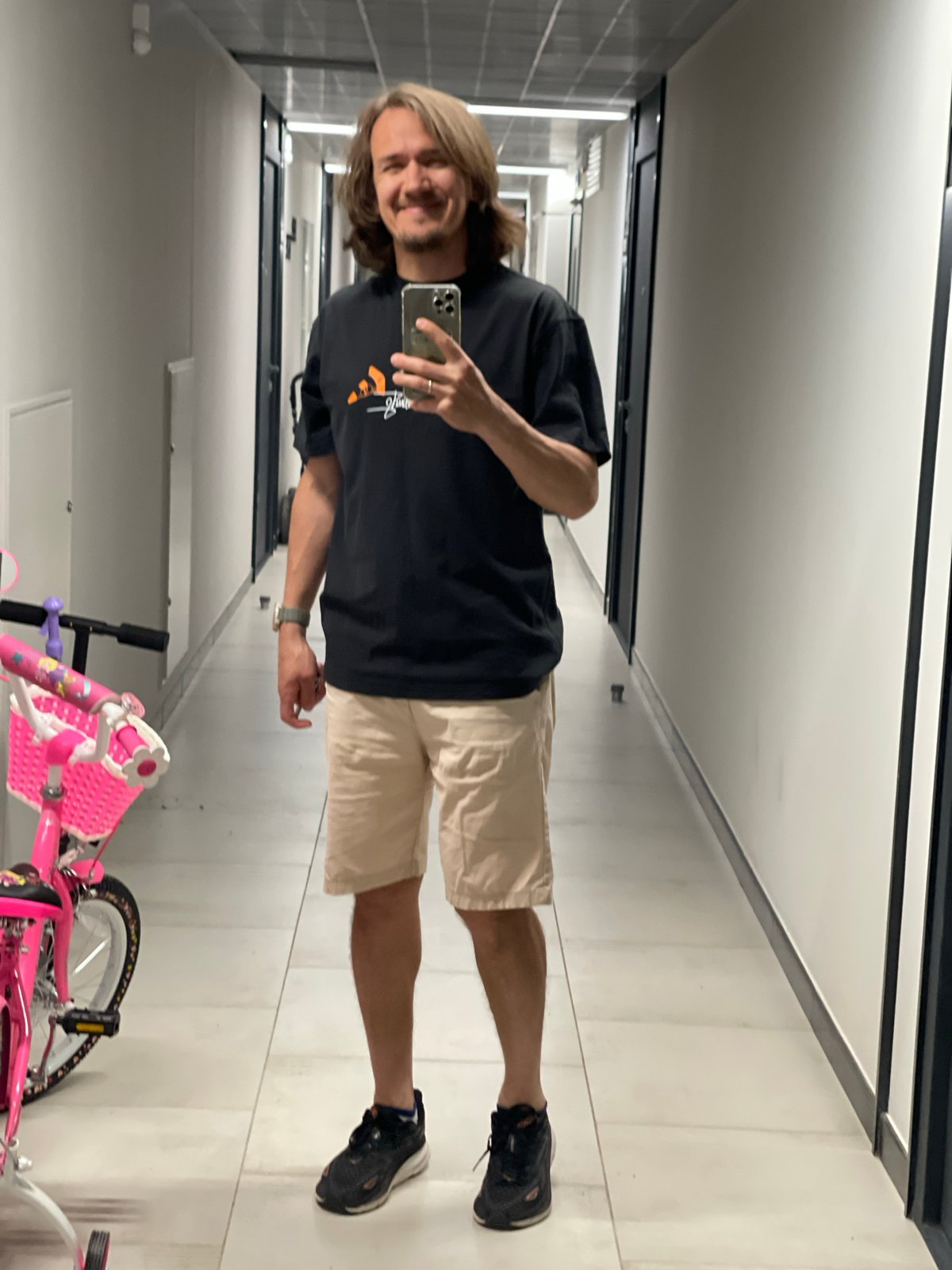 Man Takes Mirror Selfie in Indoor Hallway
