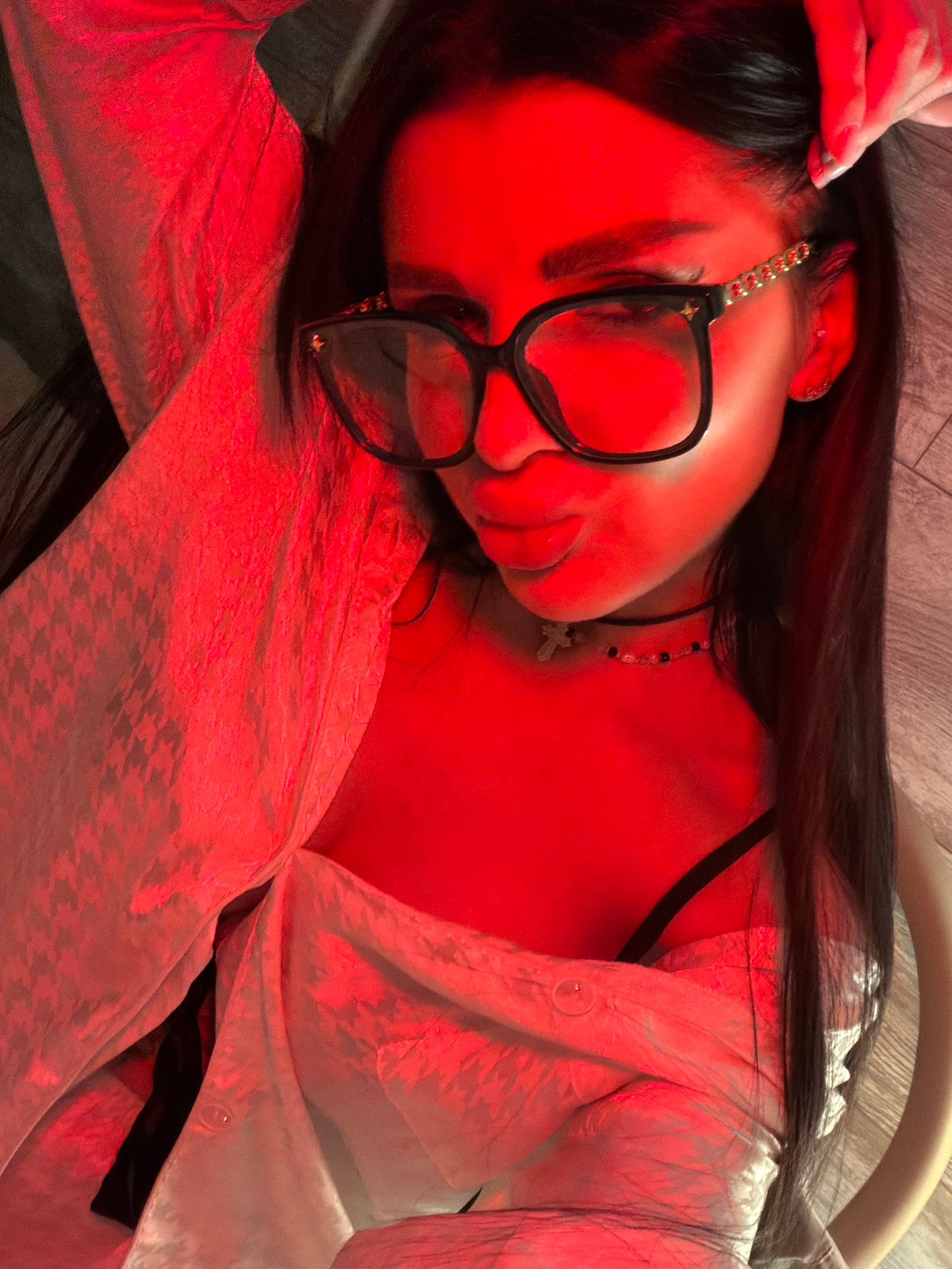 Person resting indoors in Moscow wearing glasses and jewelry