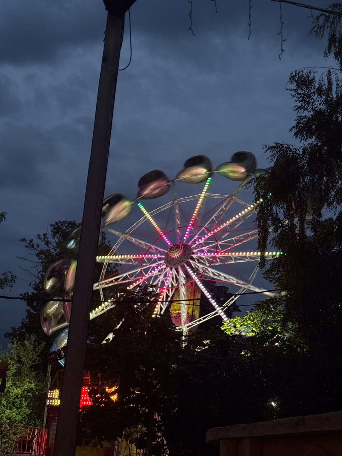 Colorful Ferris wheel lights up at dusk