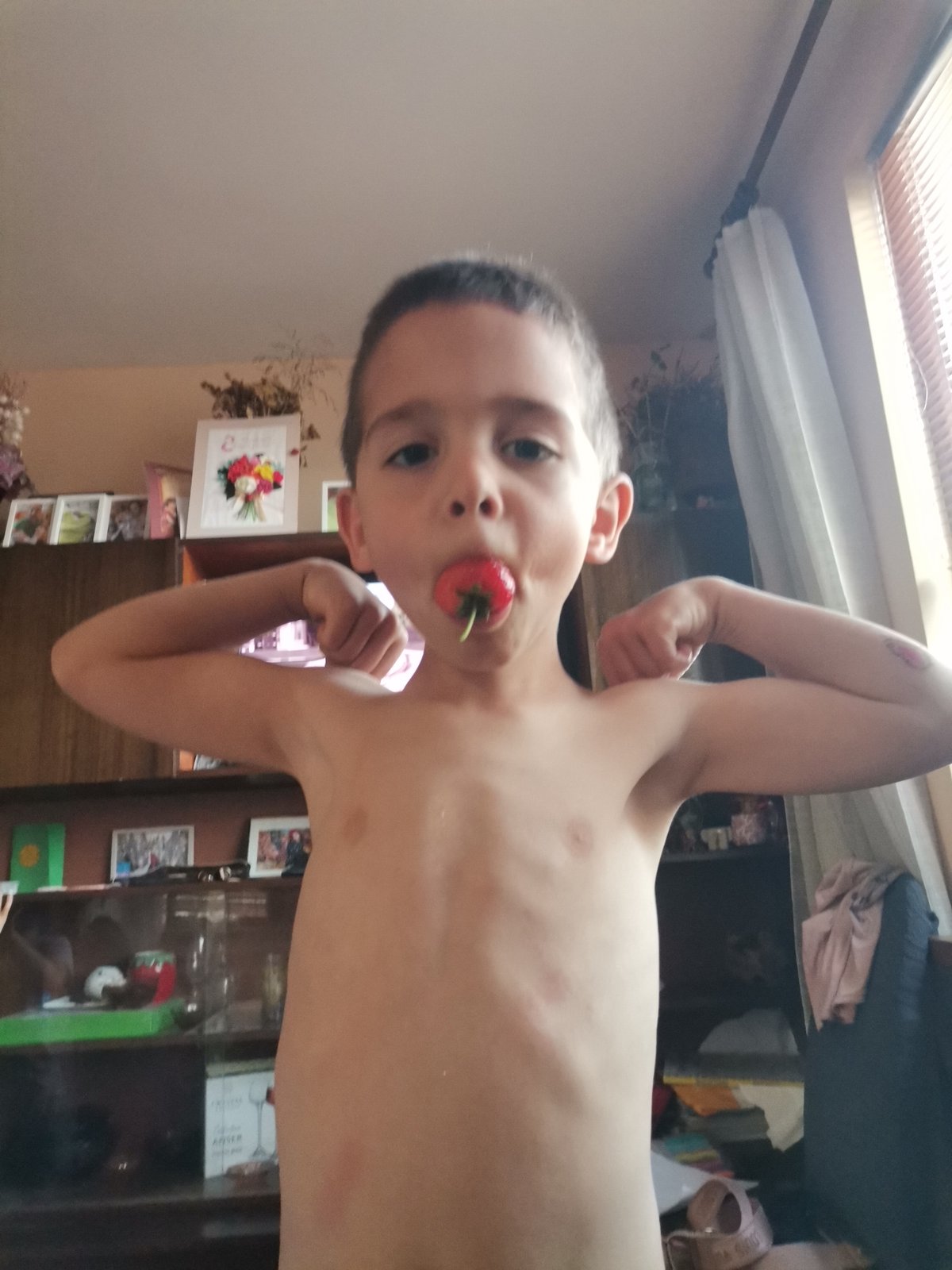 Child photographed with strawberries in Bulgarian home setting