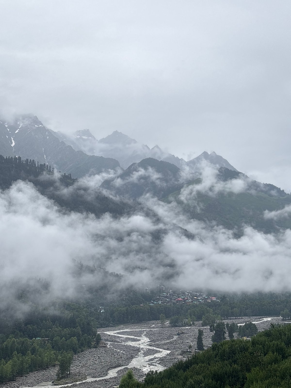 Misty river valley and forested hillside village, Vashisht
