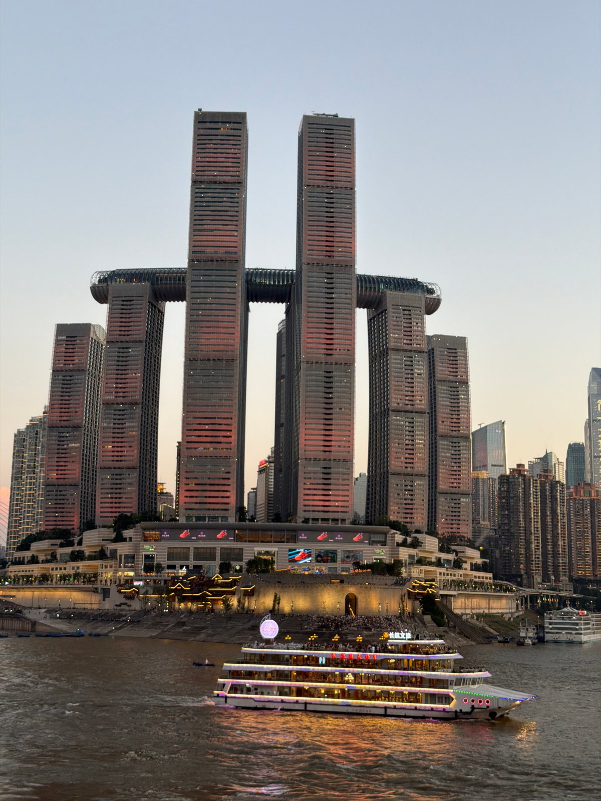 Chongqing riverfront lights up across both banks at dusk