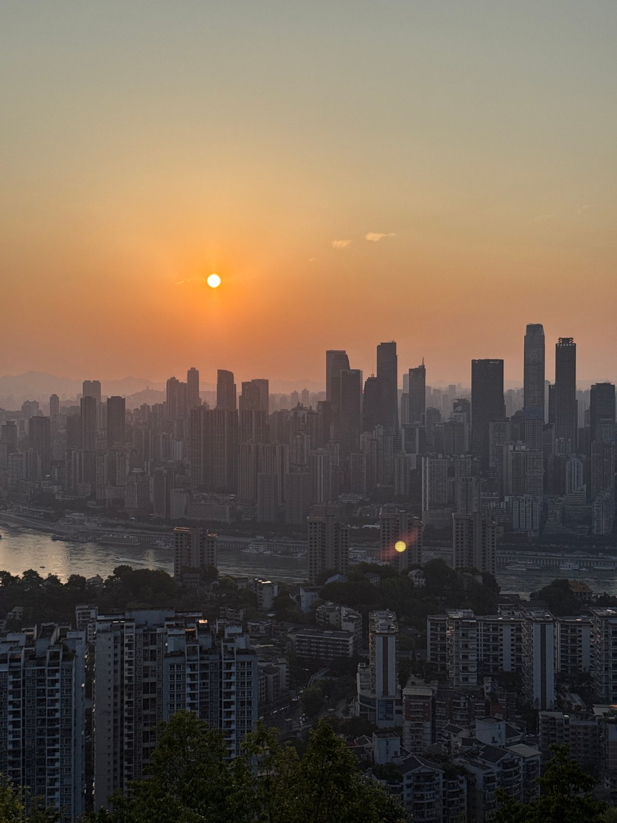Orange sunset illuminates Nan'an District cityscape with river