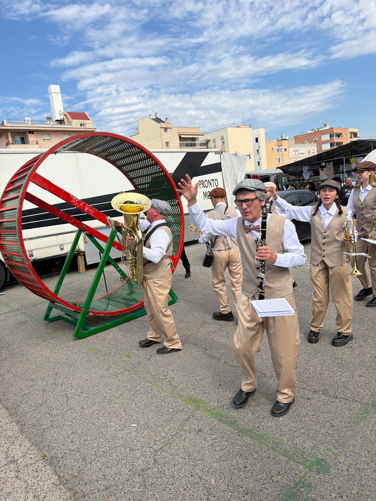 Street performers with brass band, hamster wheel entertain Spanish towns