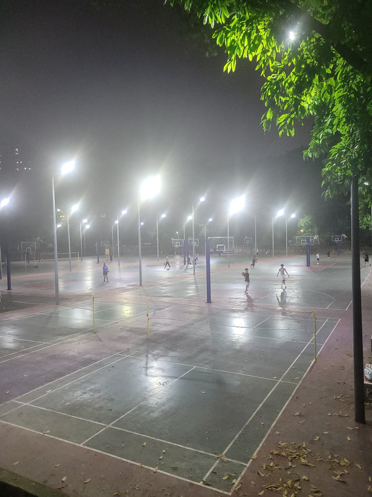 Nighttime street life and basketball activity in Shapingba District