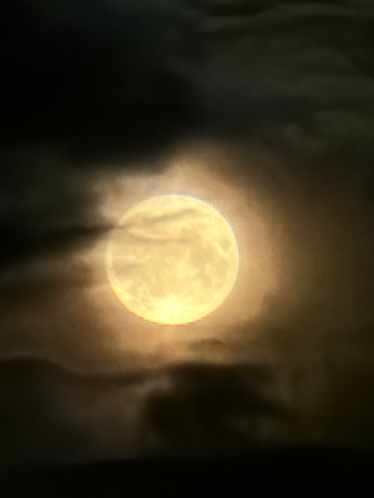 Full moon glows through dark clouds over Chaikovsky, Russia