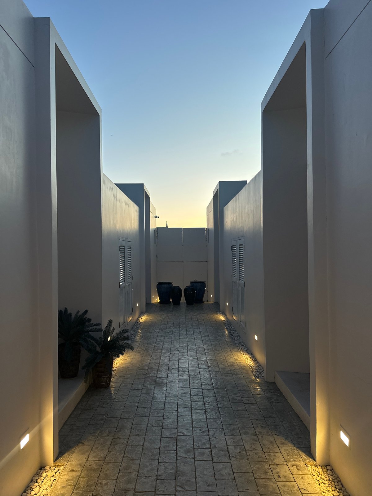 Lit concrete pathway leads to blue ceramic vases, Choeng Thale
