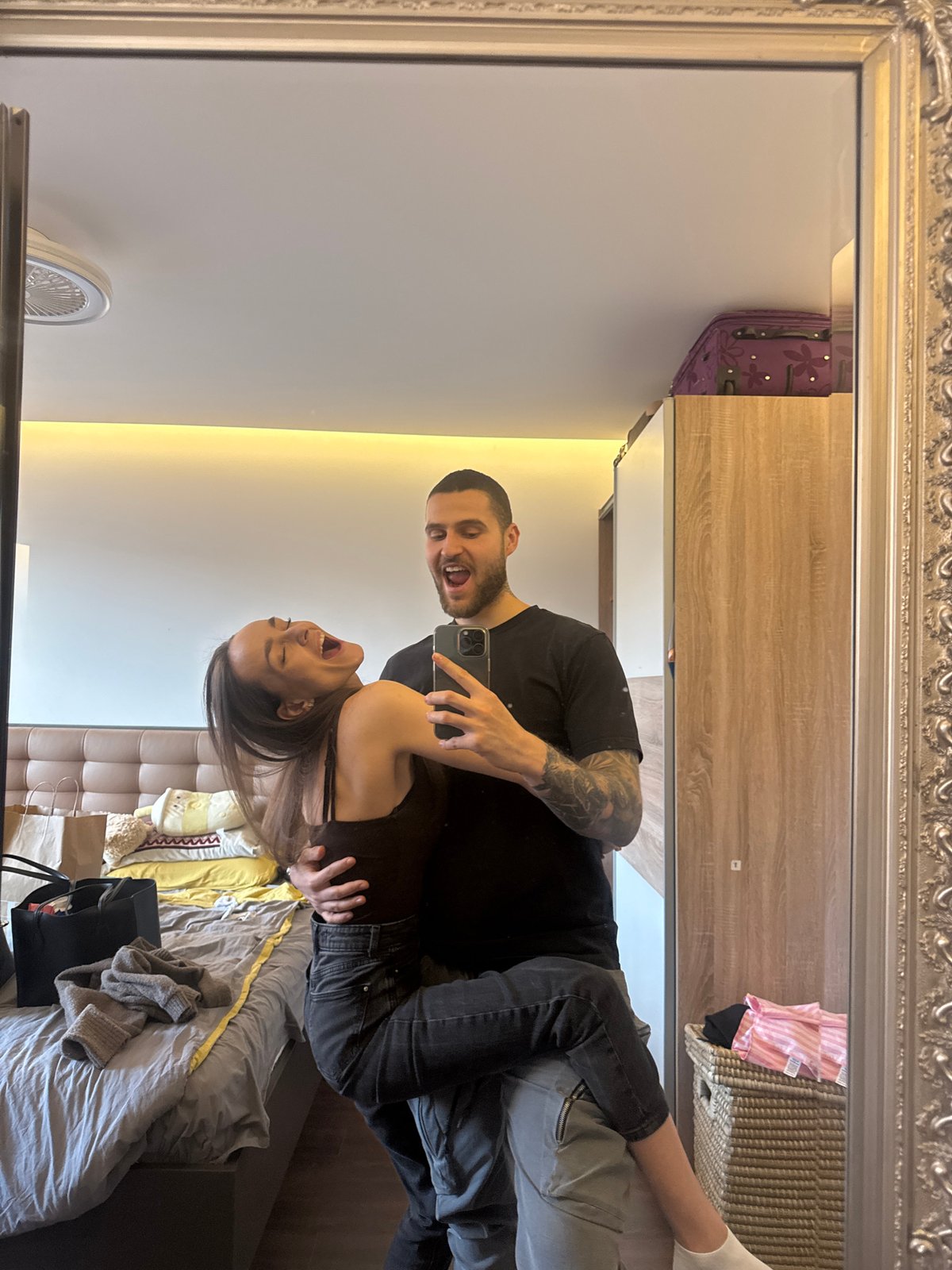 Couple takes selfies with orange phone in Sofia room