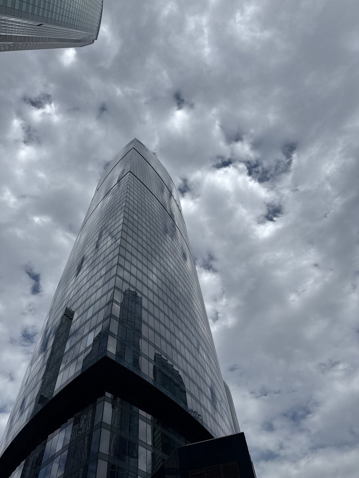 Person photographed near modern skyscrapers in Khimki, delivery robot spotted