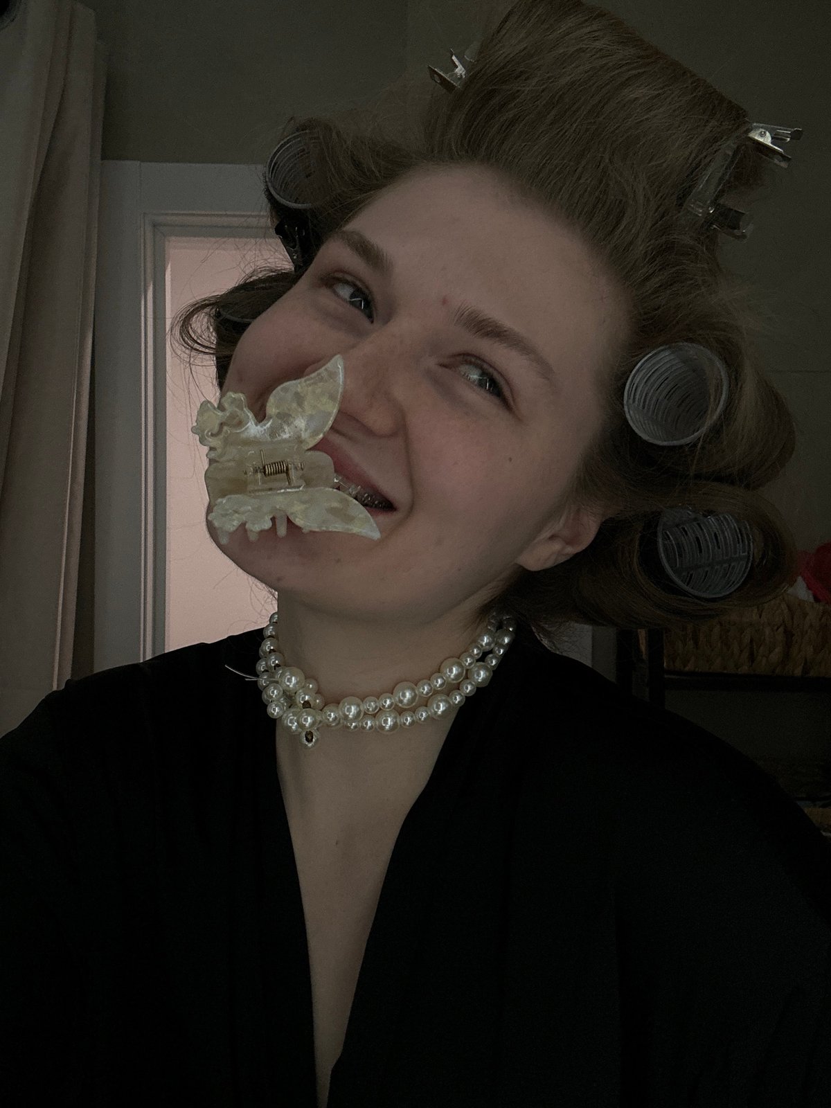 Woman in hair rollers and pearls photographed indoors in Kazan