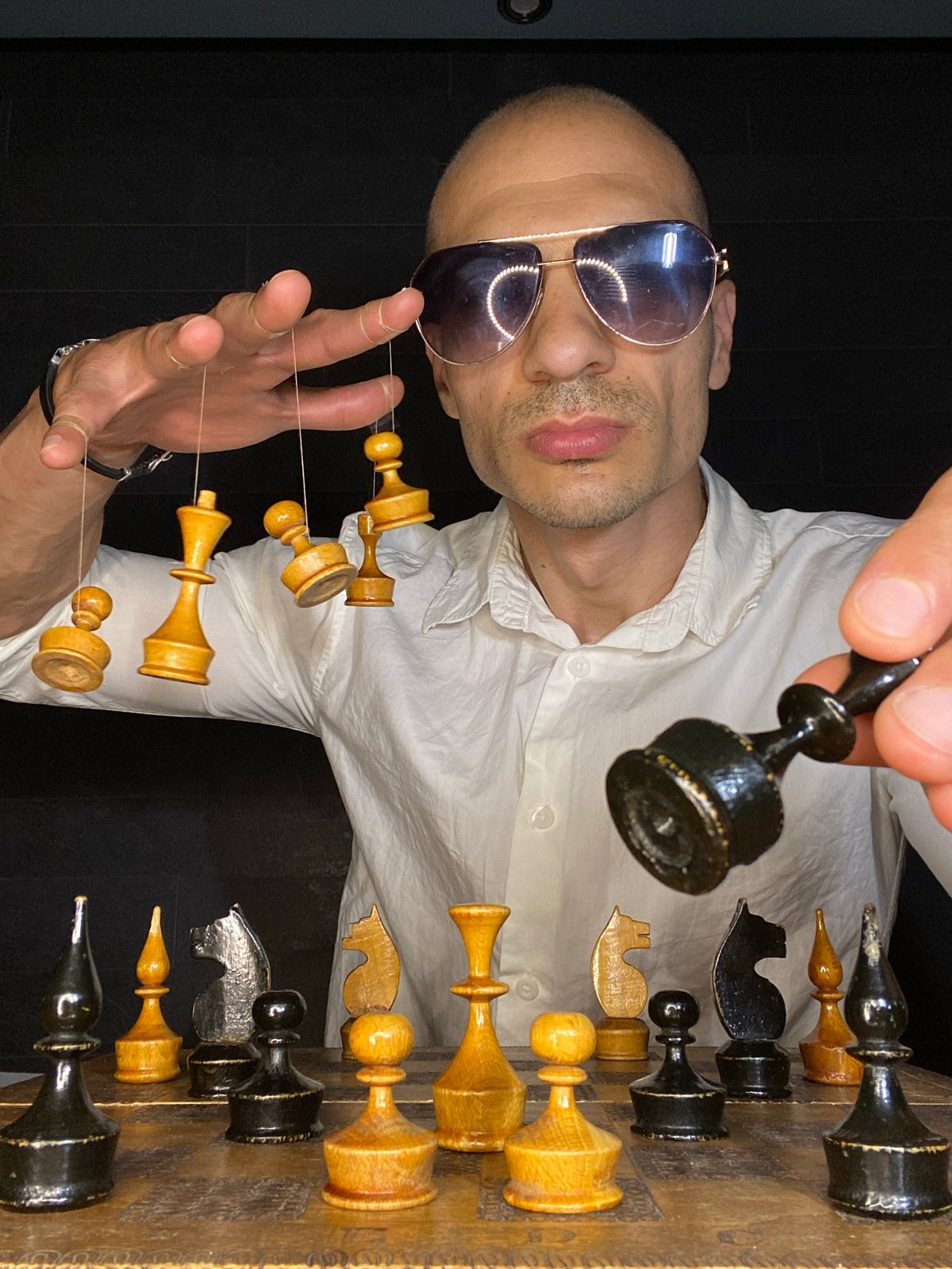 Chess pieces held and suspended in a dark Pleven room