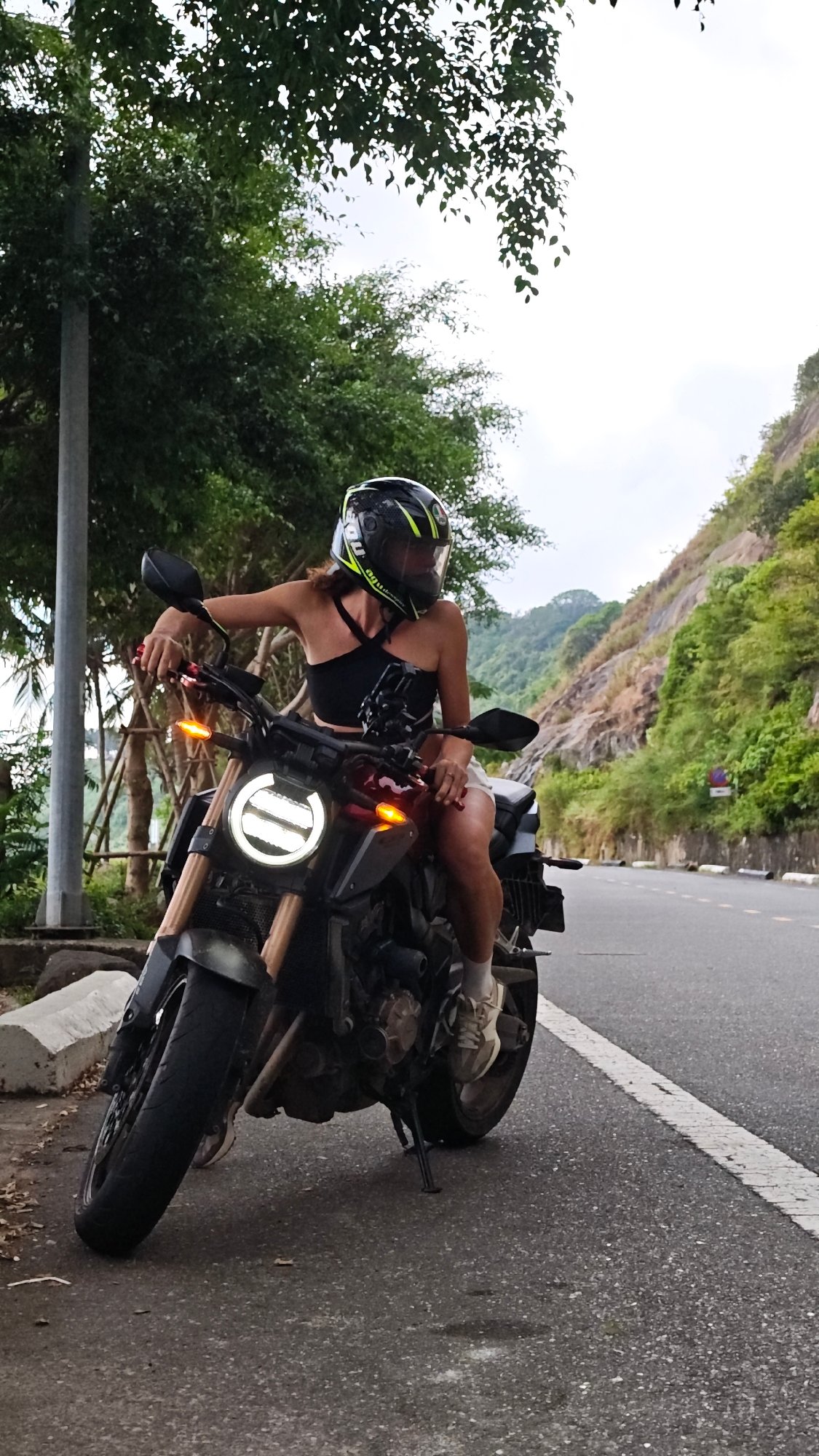 Motorcyclist pauses along coastal road in Đà Nẵng, Vietnam