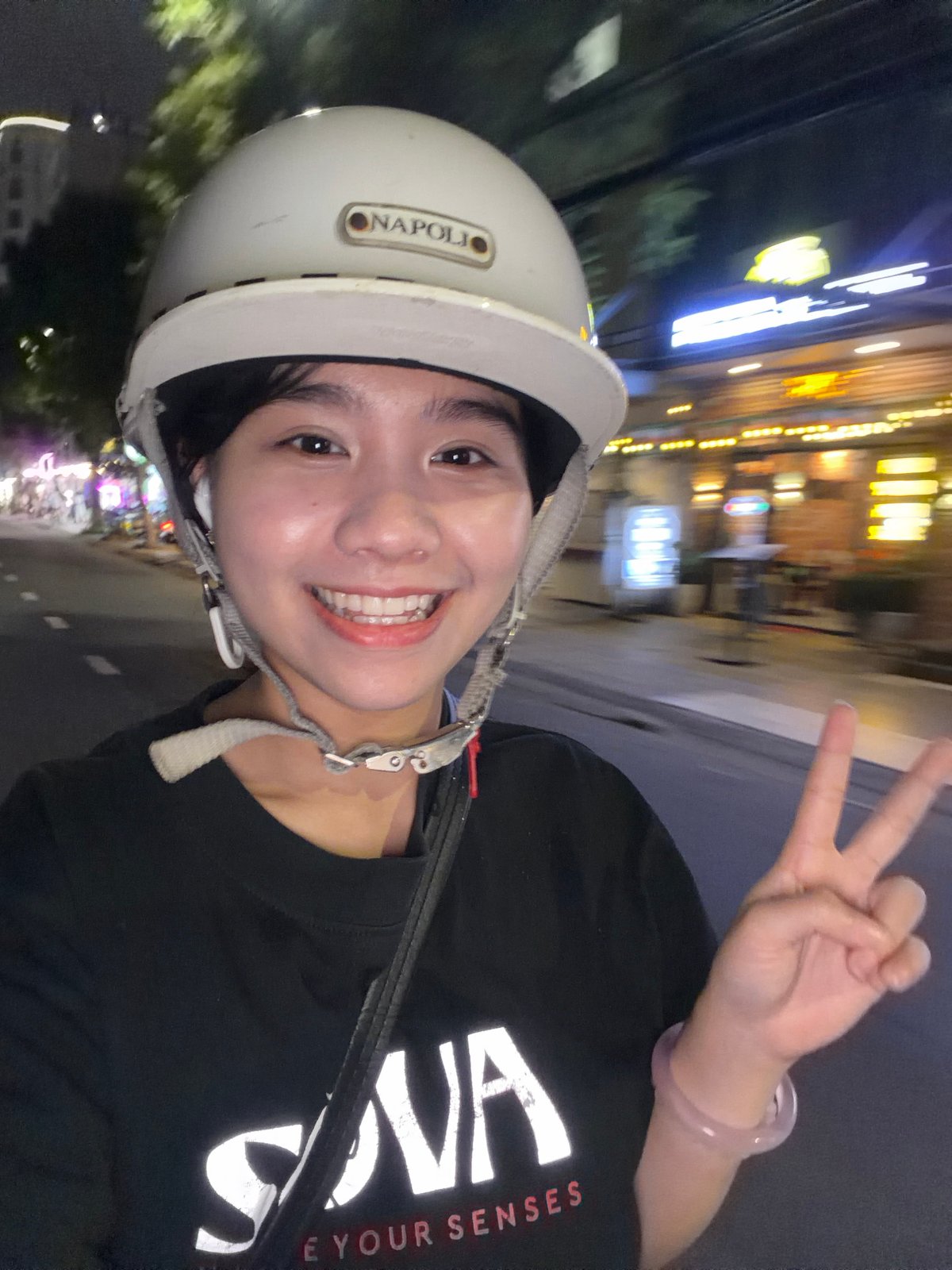 Motorcyclist makes peace sign during nighttime ride in Đà Nẵng
