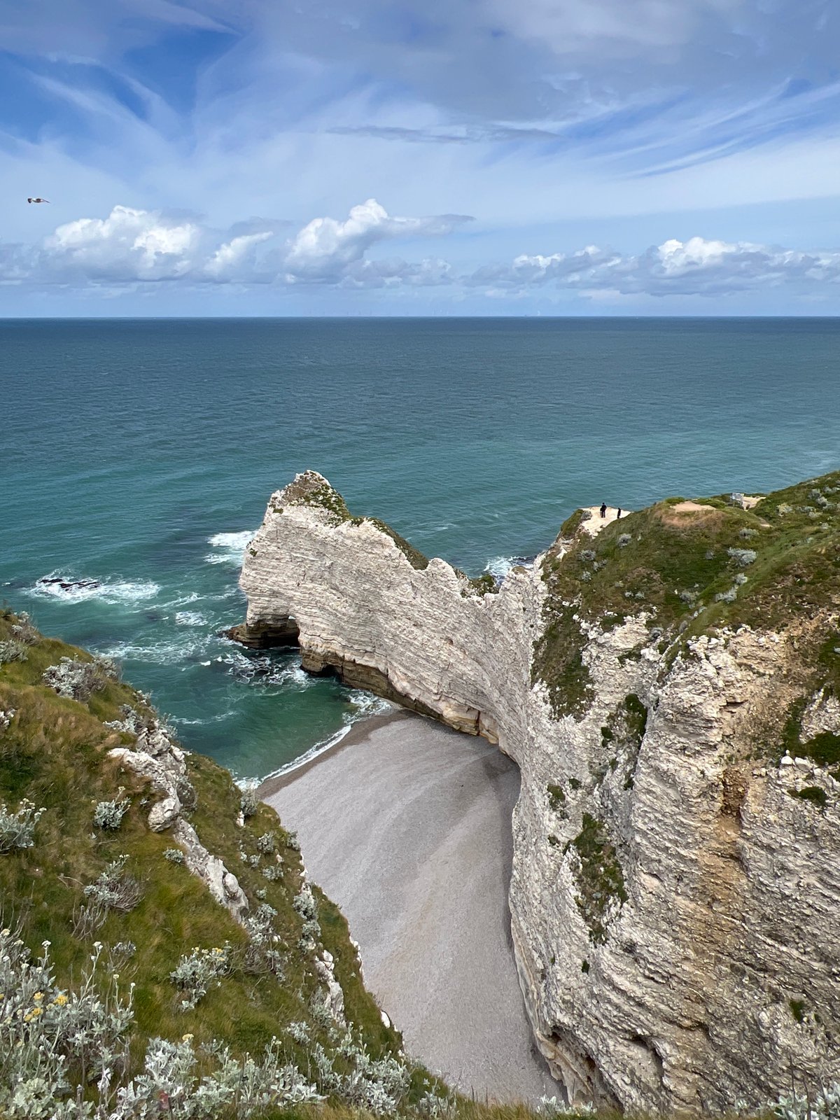 Tourists visit Étretat's dramatic chalk cliffs on June afternoon
