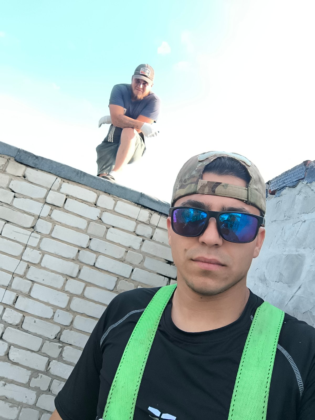 Two men spotted on rooftop wearing safety gear