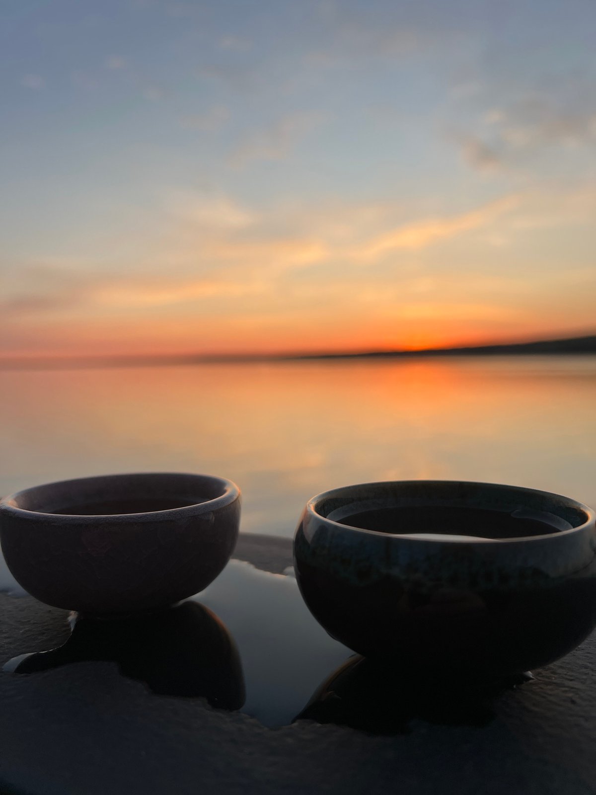 Sunset over lake documented with ceramic bowls in Chaikovsky