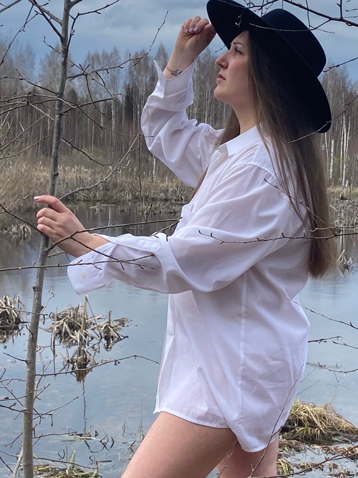 Woman observed by water near birch tree in Марковский