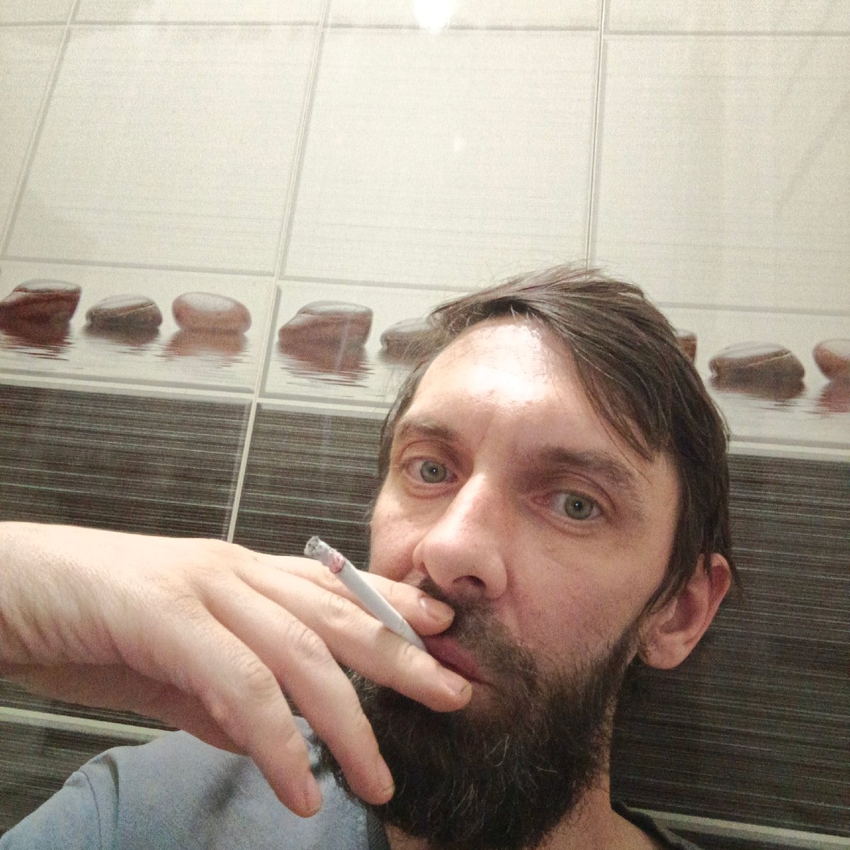 Man photographed smoking indoors in Марковский, Russia
