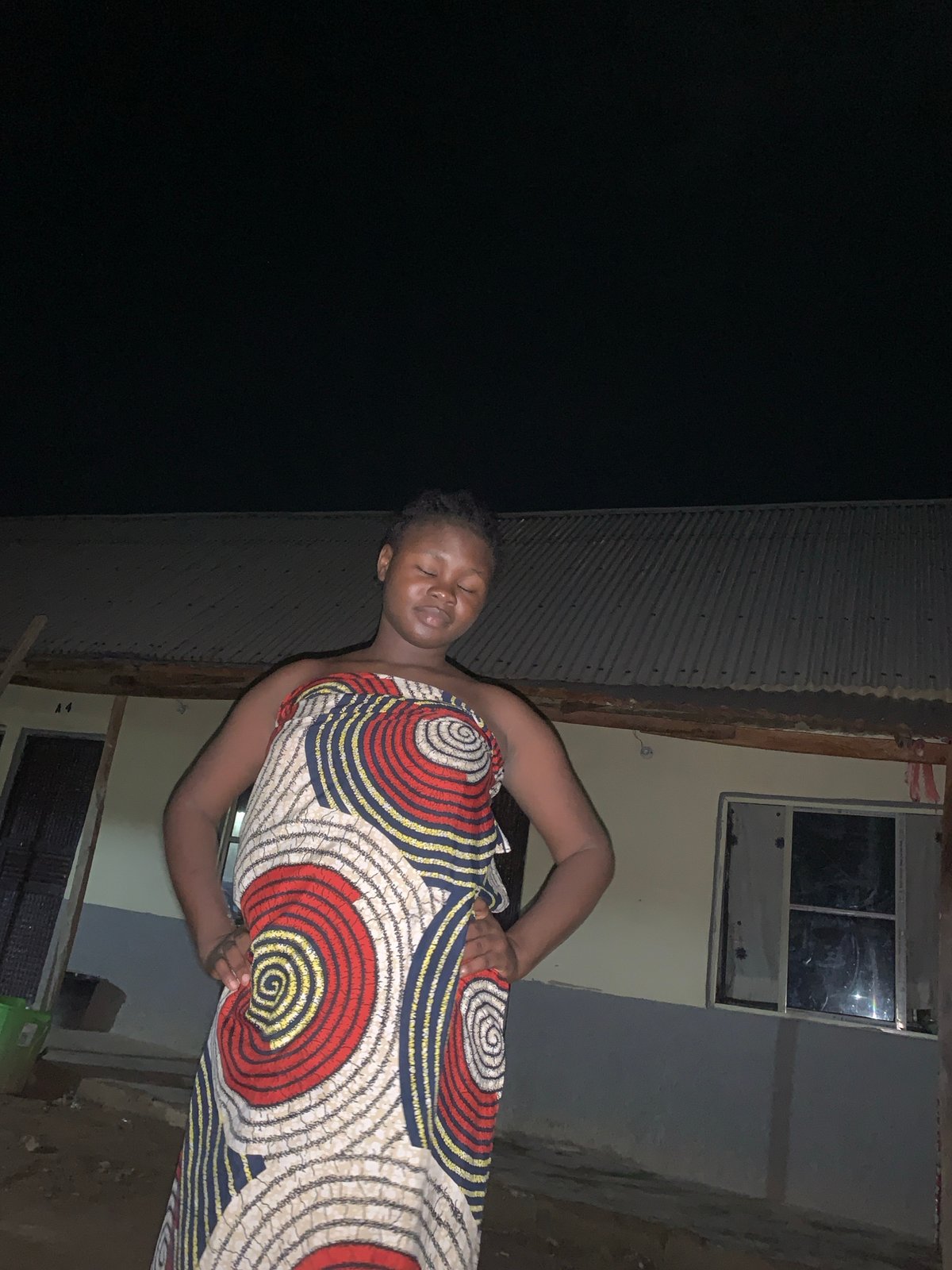 Person in patterned dress observed outside Keffi building at night